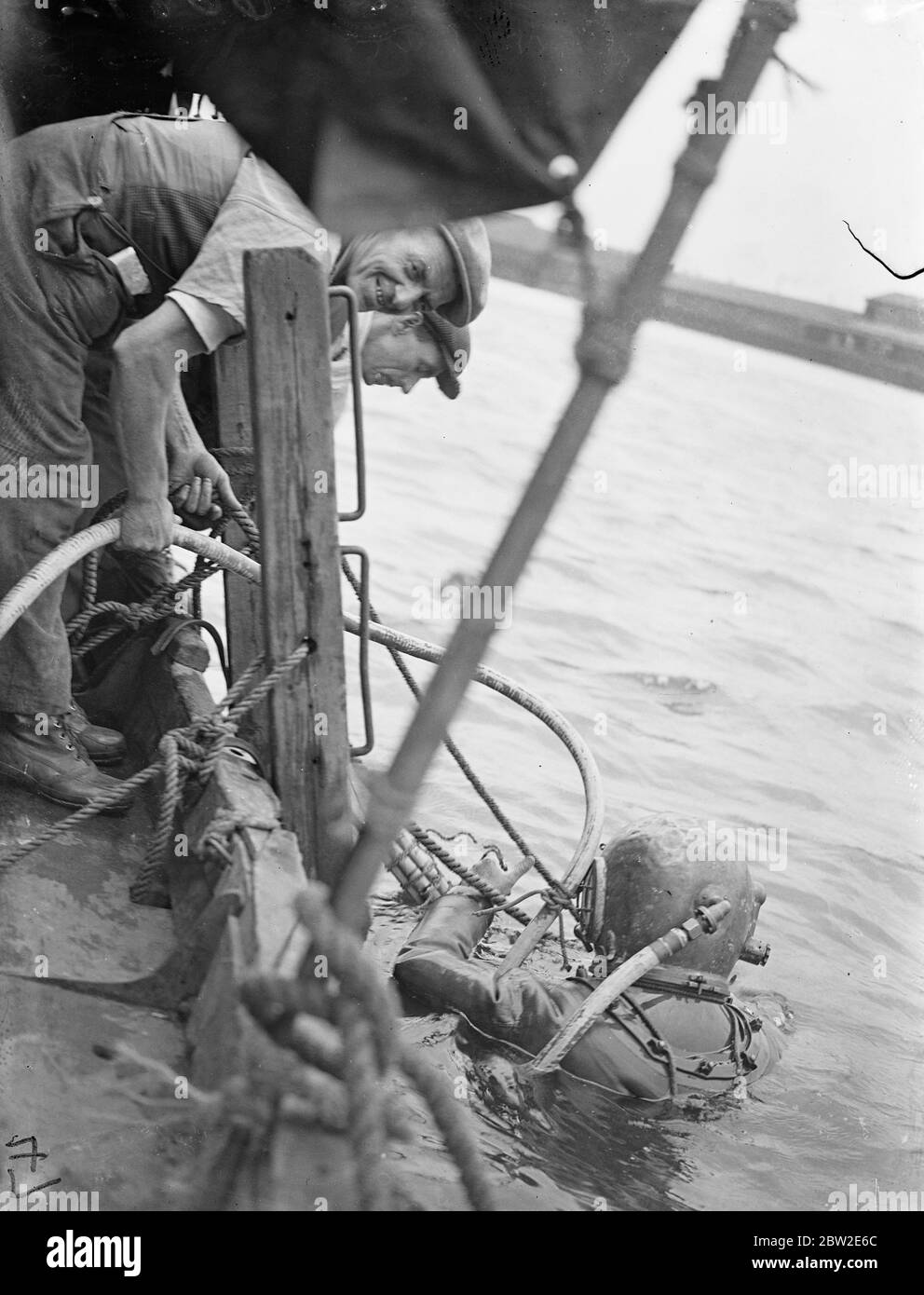 Diver Donald Macdonald steigt mit einer Ladung Gelunkohle ab, um die Fundamente der I-Anlegestelle am Royal Victoria Dock, London, zu sprengen. Die werden entfernt und moderne Kais gebaut. 23 Juli 1937 Stockfoto