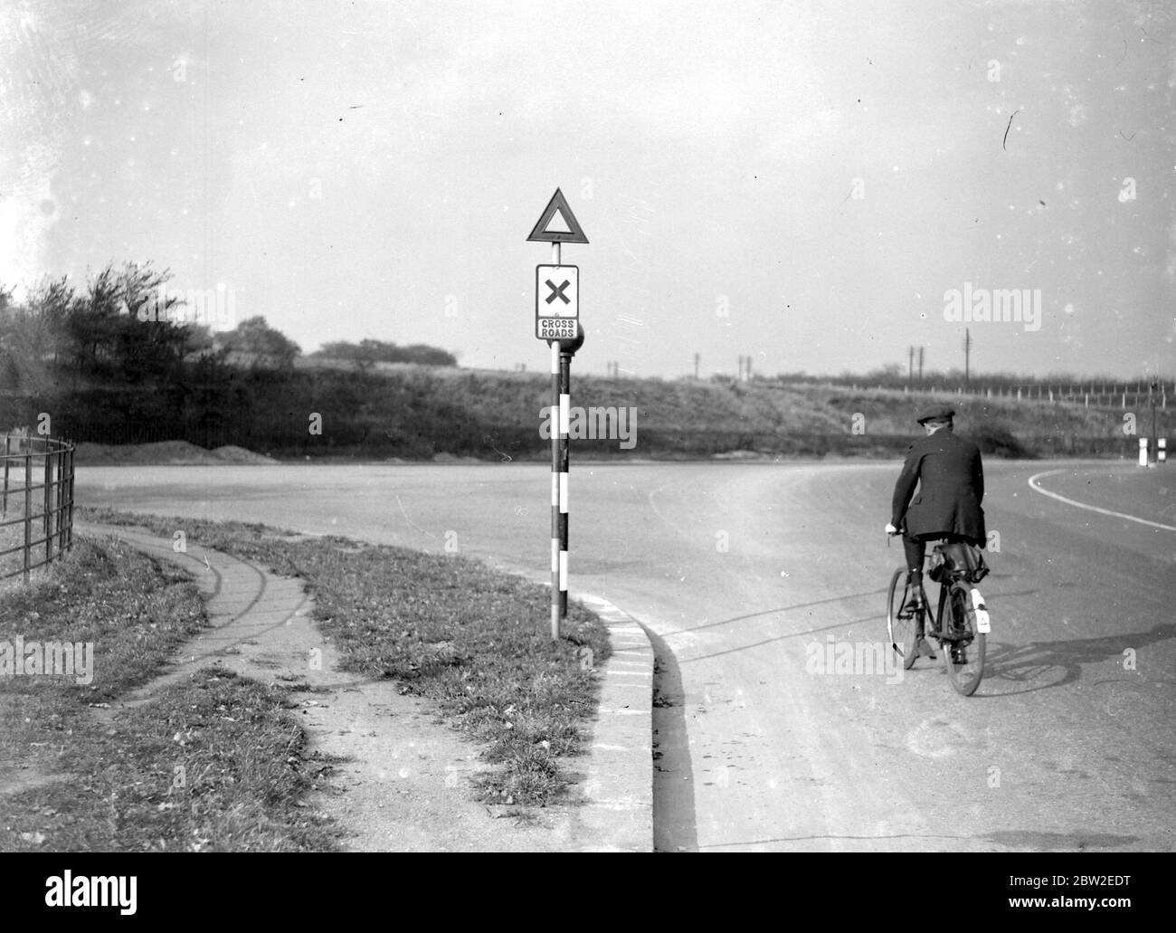 Radfahrer fahren an einem Belisha-Leuchtturm vorbei. 1934 Stockfoto