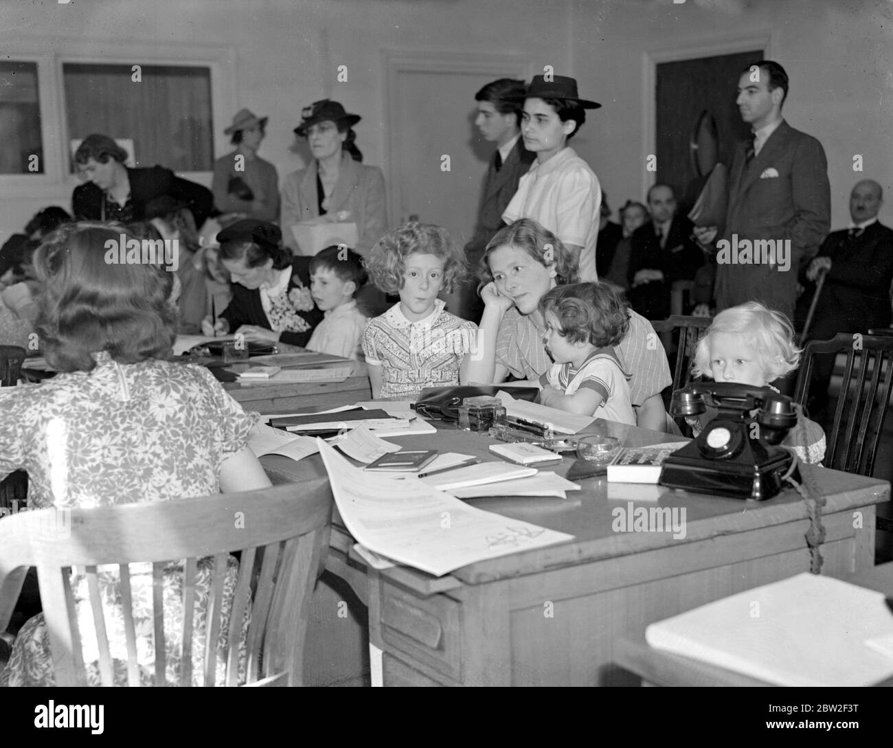 Eine Studie in Ausdrucksformen, während Mütter und ihre Kinder an der amerikanischen Botschaft teilnahmen, um Visa für die Reise in die USA zu beantragen (Kriegszeit Evakuierungsschema, 1940) 26. Juni 1940 Stockfoto