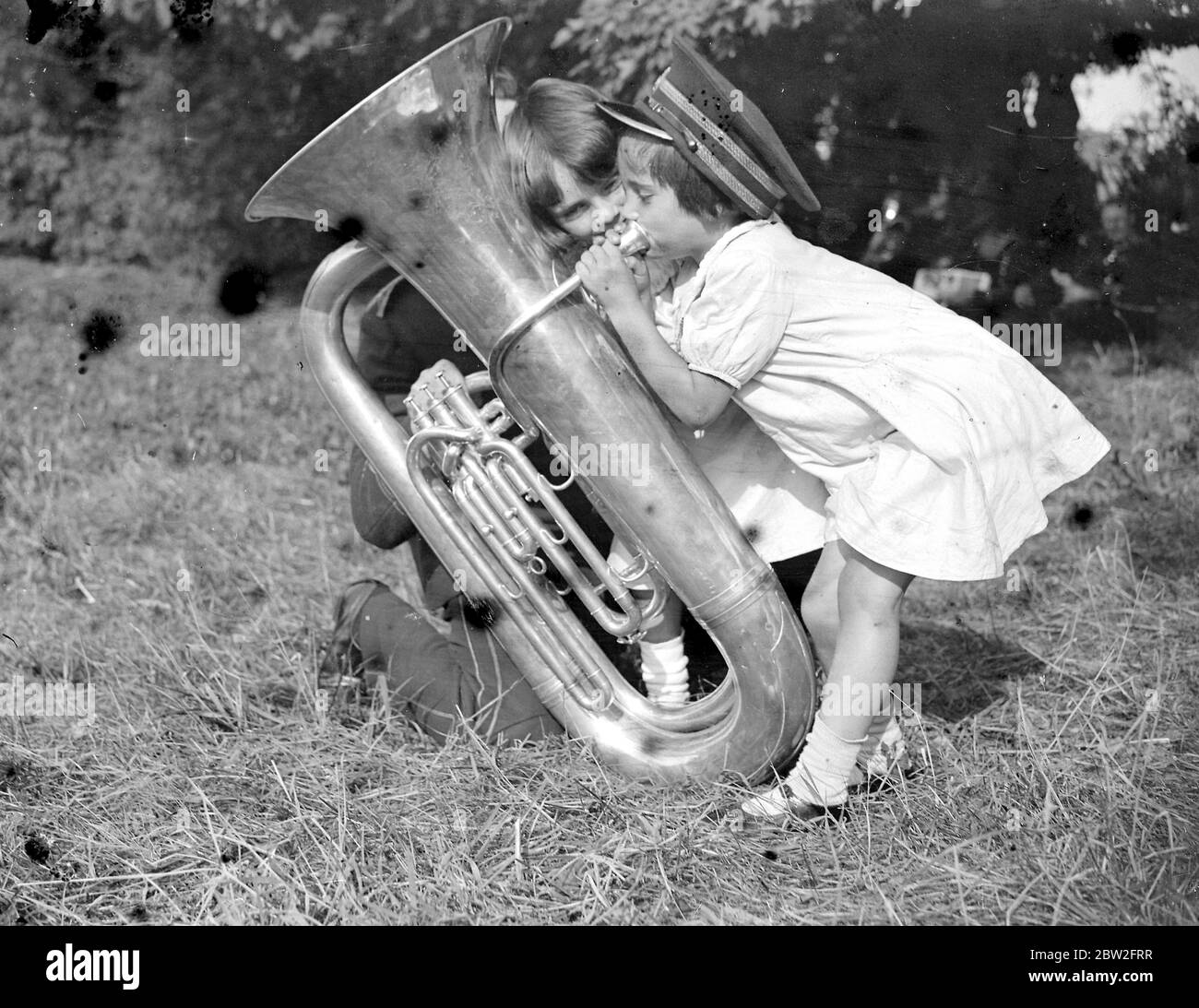 Kleine Mädchen versuchen, einen Kontrabass-Fagott zu spielen. 1934 Stockfoto