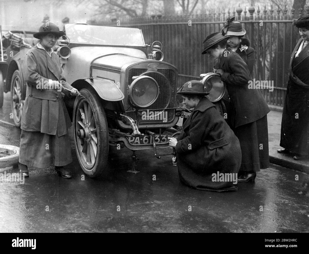 Regelung für die Unterstützung von Frauen, um ihren Lebensunterhalt als Chauffeurs zu verdienen. Wechseln eines beschädigten Reifens auf der Straße. 1914-1918 Stockfoto