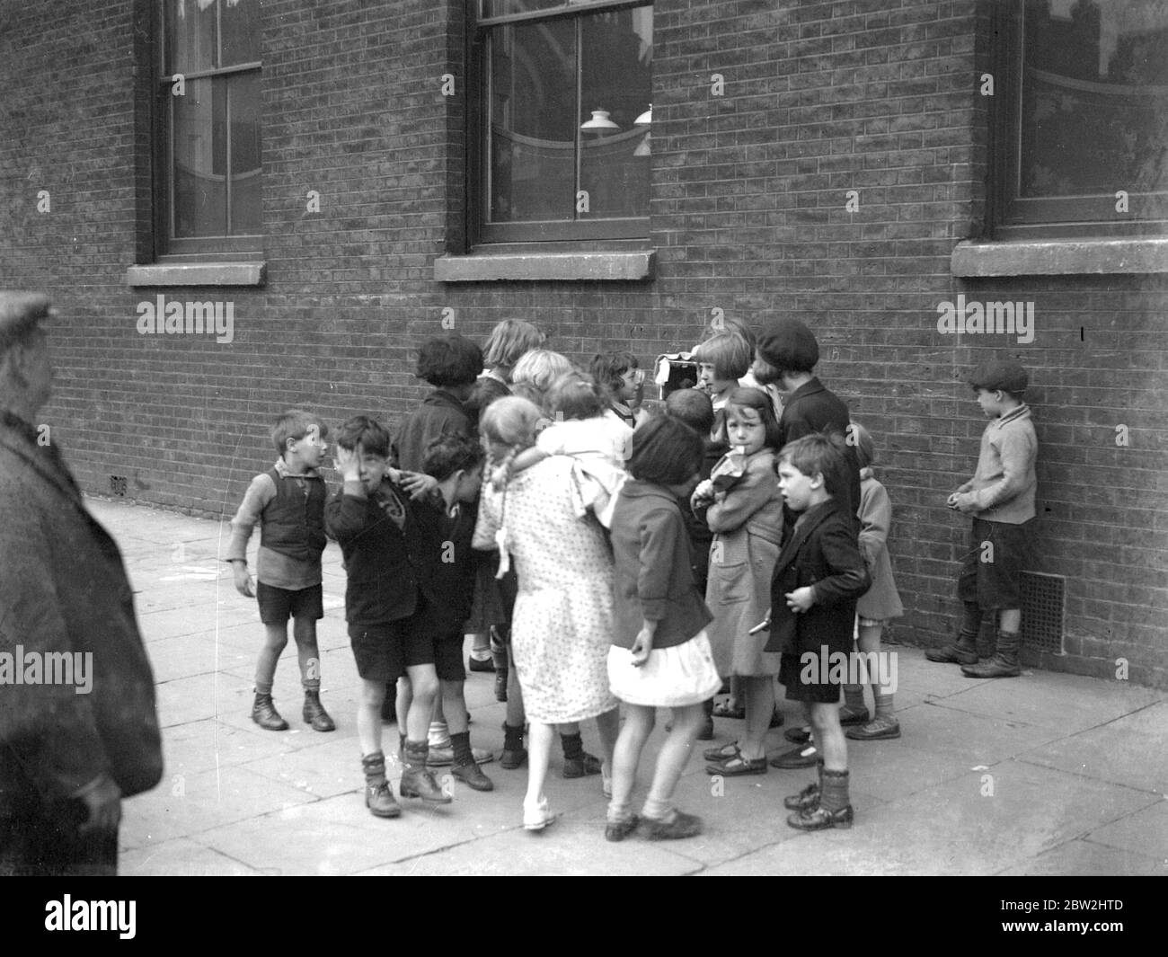 Kinder genießen es, eine Punch & Judy Show zu sehen. 1933 Stockfoto