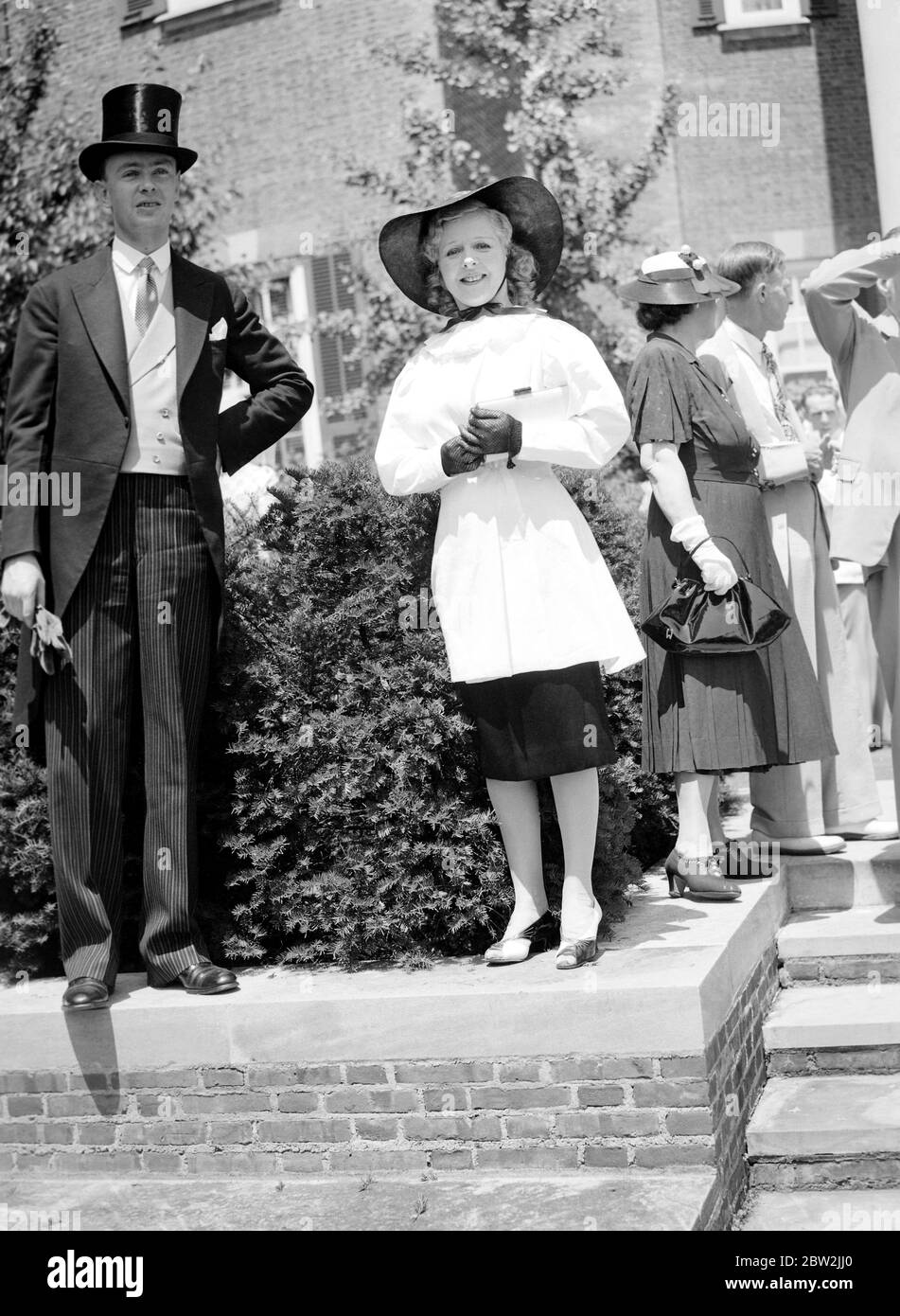 Die Königliche Tour durch Kanada und die USA von König George VI und Königin Elizabeth , 1939 Flora Le Breton , die britische Bühne und Screen-Star , trägt ein auffallendes schwarz-weiß-Outfit mit großen schwarzen Hut , Schwarze Spitzenhandschuhe und schwarze und weiße Schuhe auf dem Gelände der britischen Botschaft in Washington, USA, während der Gartenparty für den König und die Königin. Stockfoto