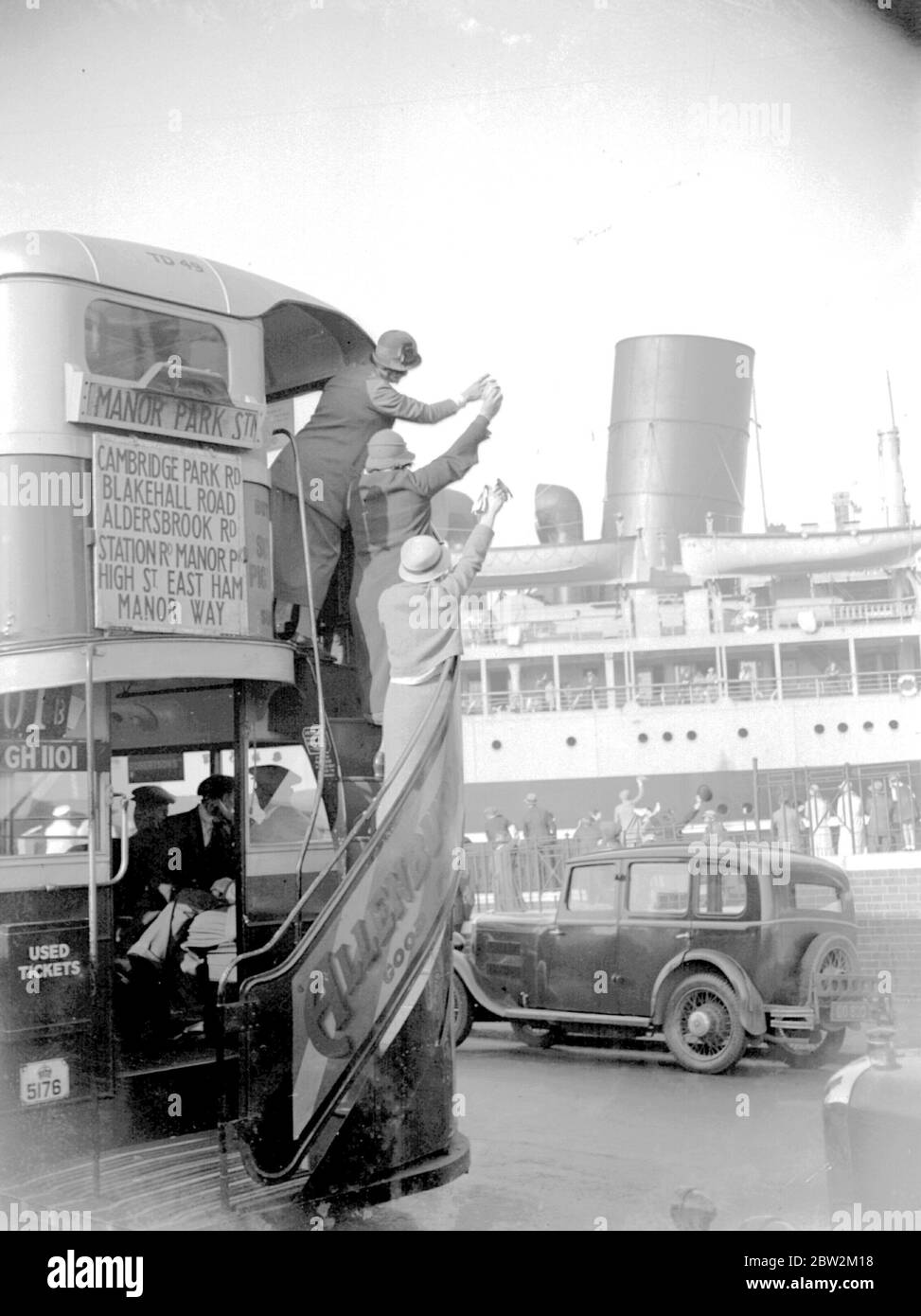 Frauen winken 1934 einem Dampfer in den London Docks zu. Boote und Züge trugen noch die meisten Briten auf Fernreisen. Foto von John Topham Stockfoto