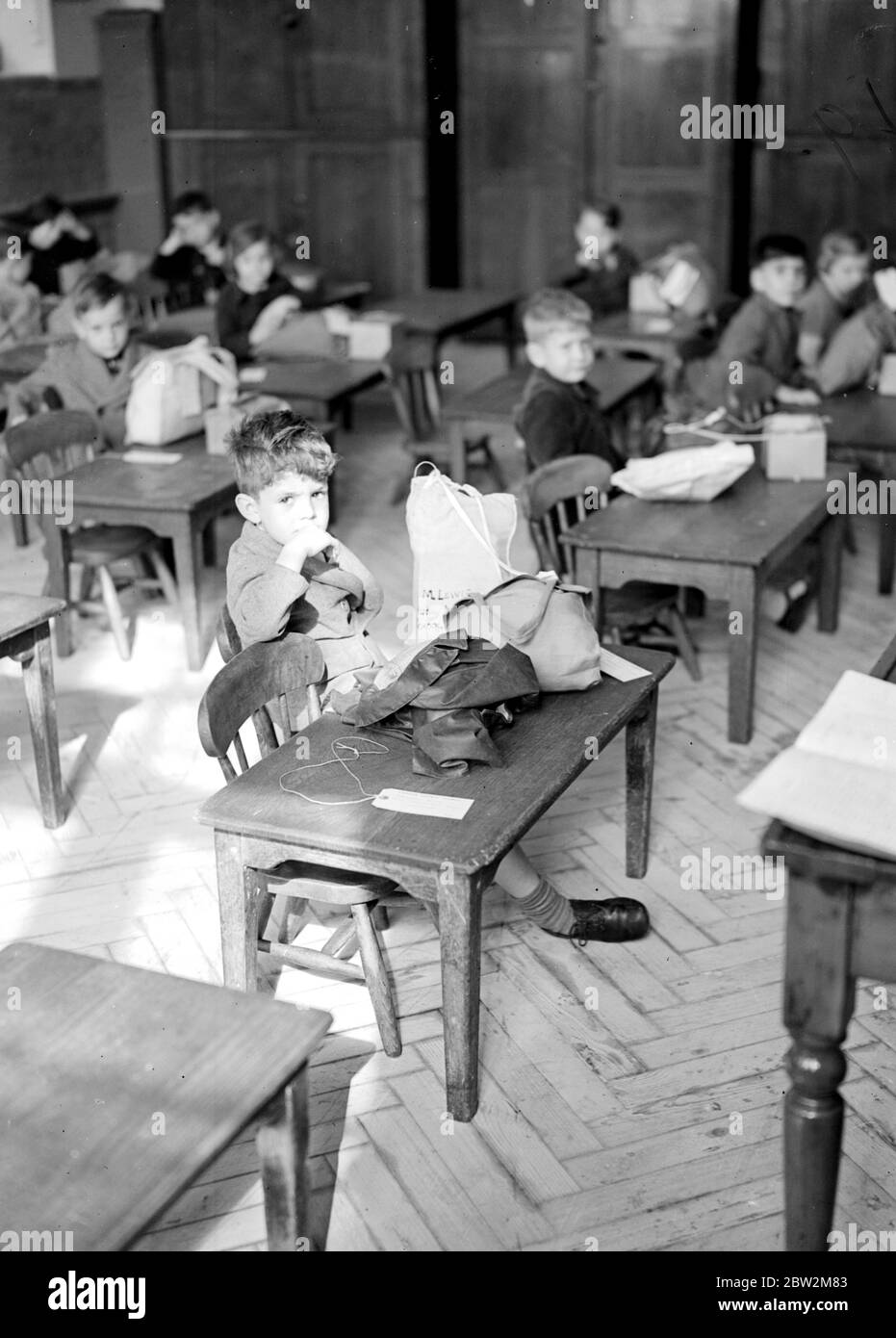 Kriegskrise, 1939. Luftangriff Vorsichtsmaßnahmen Zweiten Weltkrieg begann, und Evakuierten, wie diese in diesem Bild, begann aus London für die Sicherheit des Landes zu gießen. Mit Gasmaskenkoffer, Gepäcketiketten, die sie identifizieren, an ihrer Kleidung befestigt, war es für einige von ihnen ein großes Abenteuer, denn viele von ihnen hatten ihr Zuhause noch nie verlassen, oder sogar London zuvor. Schüler der Hugh Myddelton School sind bereit für ihre Reise. Bis 28. August 1939 Stockfoto