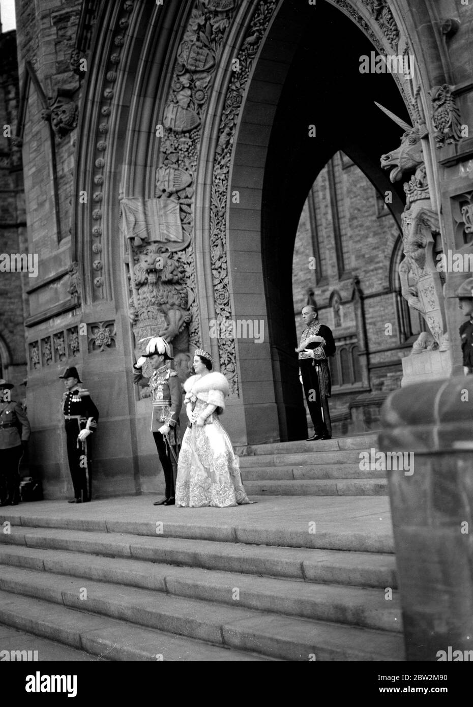 Die Königliche Tour durch Kanada und die USA von König George VI. Und Königin Elizabeth, 1939 und der König grüßt, als er und die Königin auf den Stufen des Bundesgebäudes in Ottawa stehen, nachdem der König auf dem Thron eines seiner Parlamente gesessen hatte. Hinter ihnen, im gotischen Torbogen, steht der kanadische Premierminister, Herr W. L. Mackenzie King. Stockfoto