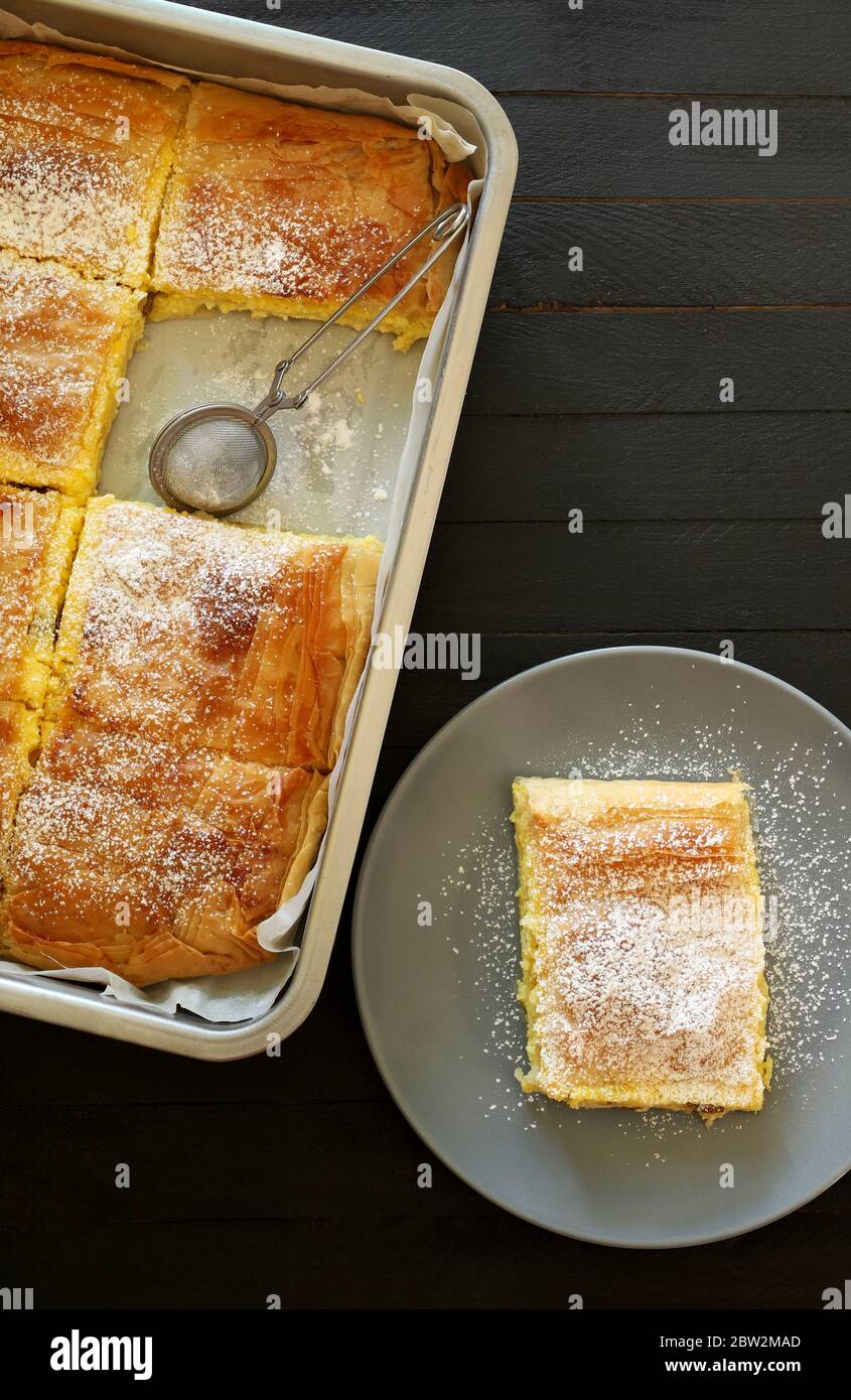 Konzept der griechischen Küche. Hausgemachte traditionelle griechische Bougaza, Phyllo-Gebäck mit Sahne auf dunklem Hintergrund gefüllt.Draufsicht. Stockfoto