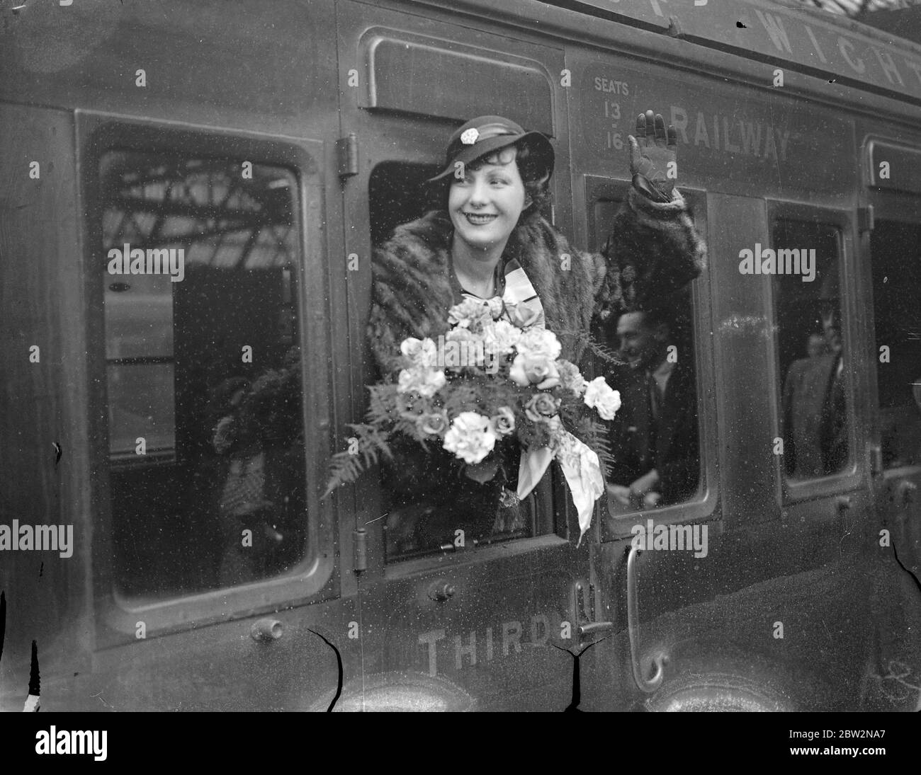 Keine Chance, Heimweh dieses Mal sein. Binnie Barnes, verlässt London für Amerika, von New York nach Kalifornien mit dem Flugzeug. Miss Binnie Barnes, die englische Schauspielerin, links Waterloo Station, London, auf der Aquitania Boot Zug für die Vereinigten Staaten. Vor achtzehn Monaten Miss Barnes aus nach Kalifornien, aber bekam Heimweh in New York und kam zurück. Sofort kommt sie in New York an, diesmal wird sie ein Flugzeug direkt nach Kalifornien bringen. Ihr Vertrag mit der Hollywood-Filmgesellschaft erlaubt ihr, nach drei Monaten nach Hause zurückzukehren. Foto zeigt, Miss Binnie Barnes winkt Abschied von ihrem Auto Stockfoto