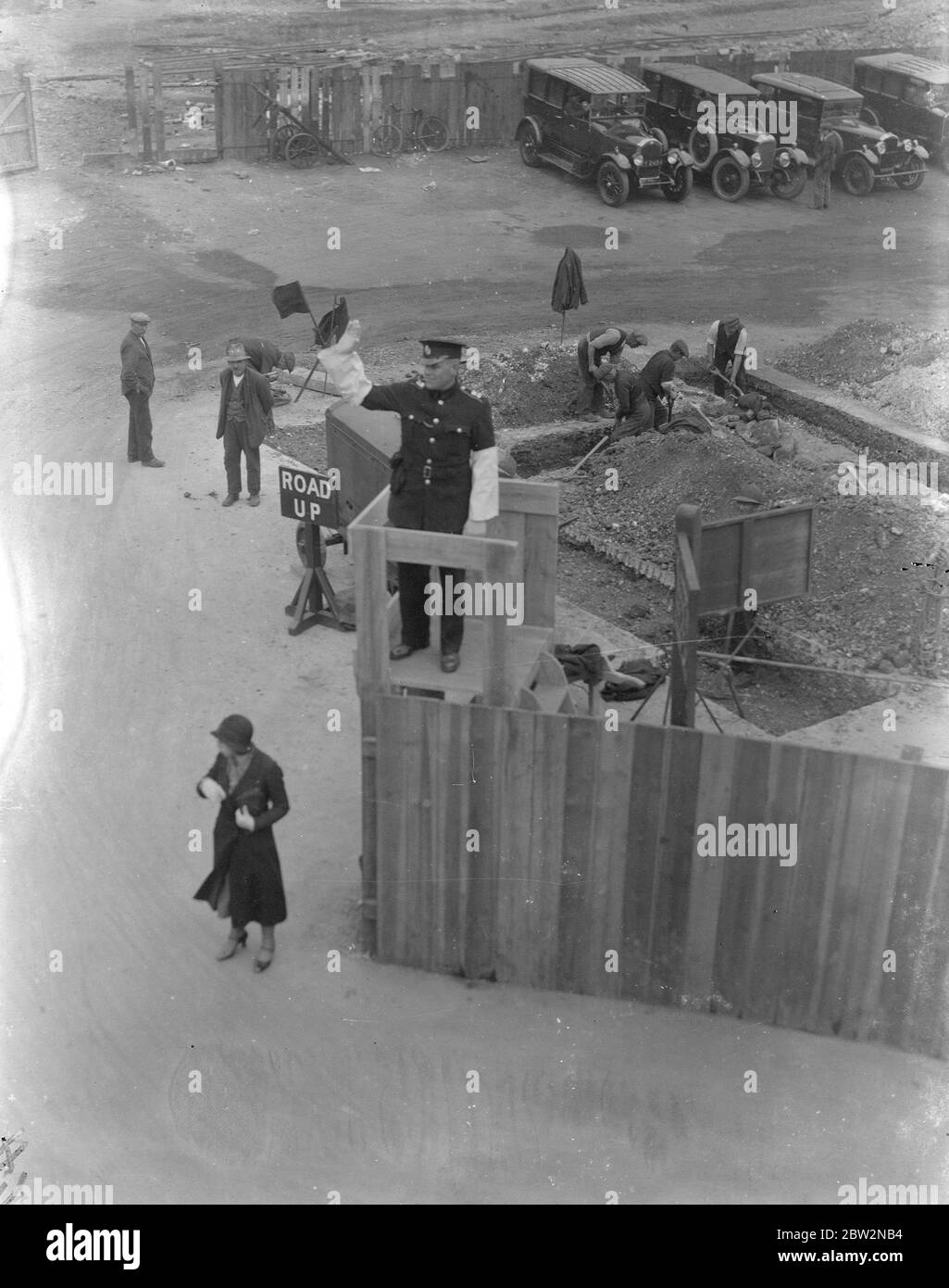Die Verkehrslenkung von einer erhöhten Plattform in Southampton . An einer geschäftigen Kreuzung in Southampton, wo eine Reihe von Straßenarbeiten im Gange sind, wurde der Verkehrspolizist mit einer Plattform ausgestattet, von der aus der Verkehr zu lenken. Foto zeigt, ein Polizist, der den Verkehr von der erhöhten Plattform in Southampton leitet. 23. April 1934 Stockfoto