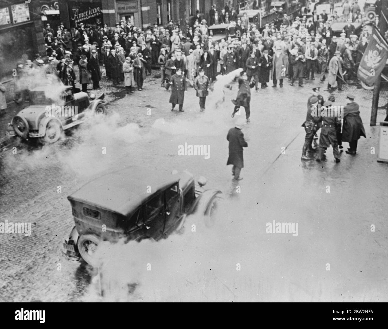 Die Polizei benutzt Tränengas, um rote Unruhen in Pennsylvania zu brechen. Tränengas wurde von der Polizei von McKeesport, Pennysylvania verwendet, um einen Aufstand zu brechen, wenn Kommunisten versuchten, eine Sitzung auf der Straße in Trotz des stadtrats zu halten. Acht Personen, darunter zwei Frauen, wurden verhaftet. Eine Szene während des Aufruhrs, die das Tränengas zeigt, das herumschwimmt und einen Randalierer (rechts), der von der Polizei verhaftet wird. 14 Februar 1932 Stockfoto