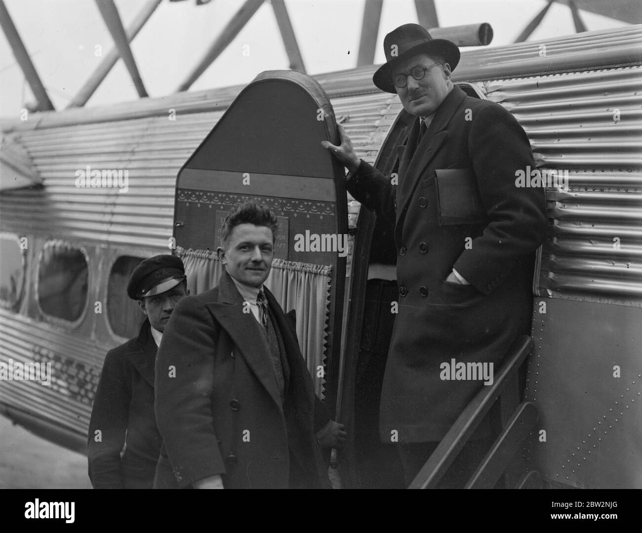 Geschwindigkeitsrekordhalter fahren nach Frankreich, um Tag und Nacht bei mehr als 100 Meilen pro Stunde zu reisen. Herr George Eyston , Inhaber des Weltrekordes für Babyautos , und Herr A W Denby ( der den Platz von Herrn Kay Dan nahm ) Crack Rennmotorkuklisten, die einen Weltrekord im Jahr 1927 mit 127 Meilen pro Stunde auf einem Motorrad , Links mit dem Flugzeug von Croydon für die Montlhery Strecke, Frankreich, wo sie in einer geraden acht Zylinder Auto versuchen, Tag und Nacht bei mehr als 100 Meilen pro Stunde für drei Tage zu reisen. Herr George Eyston (mit Brille) und Herr A W Denby werden bei der Abfahrt in Croydon in das Flugzeug einsteigen. Stockfoto