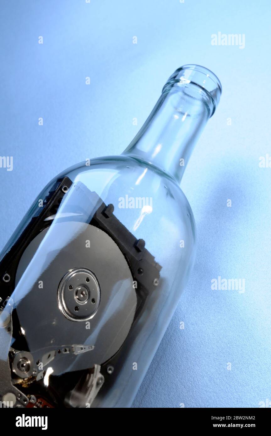 Eine Computerfestplatte in einer durchsichtigen Glasflasche Stockfoto