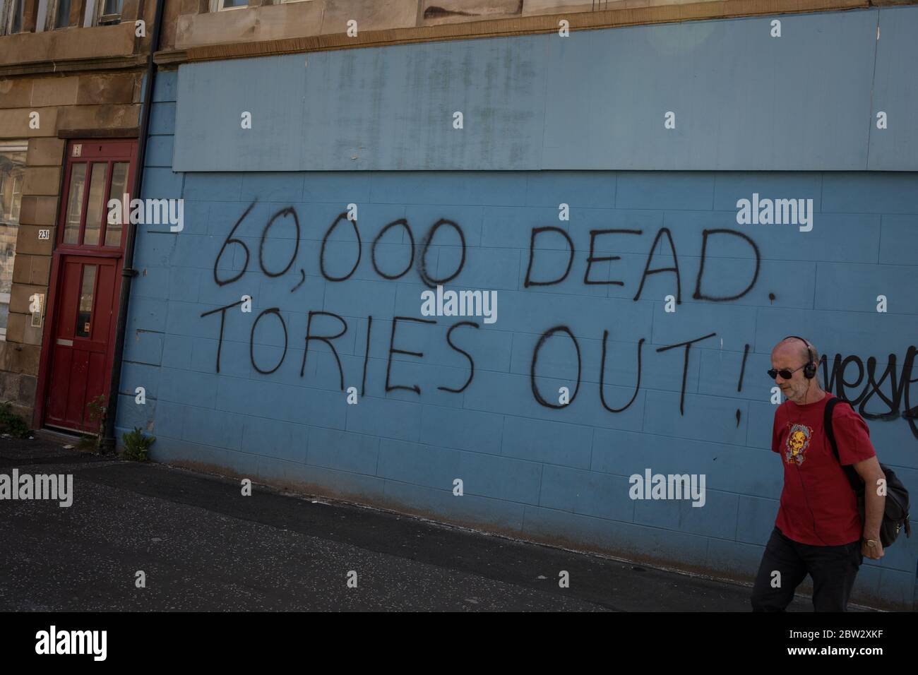 Glasgow, Großbritannien, 29. Mai 2020. Graffiti mit der Aufschrift '60,000 Dead, Tories Out!' Ist an einer Mauer im Stadtteil Govanhill der Stadt erschienen und zeigt lokale Wut über die Politik und den Umgang mit dem Coronavirus Covid-19 Gesundheitspandemie durch die konservative Regierung Großbritanniens unter der Leitung von Premierminister Boris Johnson. In Glasgow, Schottland, am 29. Mai 2020. Foto: Jeremy Sutton-Hibbert/Alamy Live News. Stockfoto