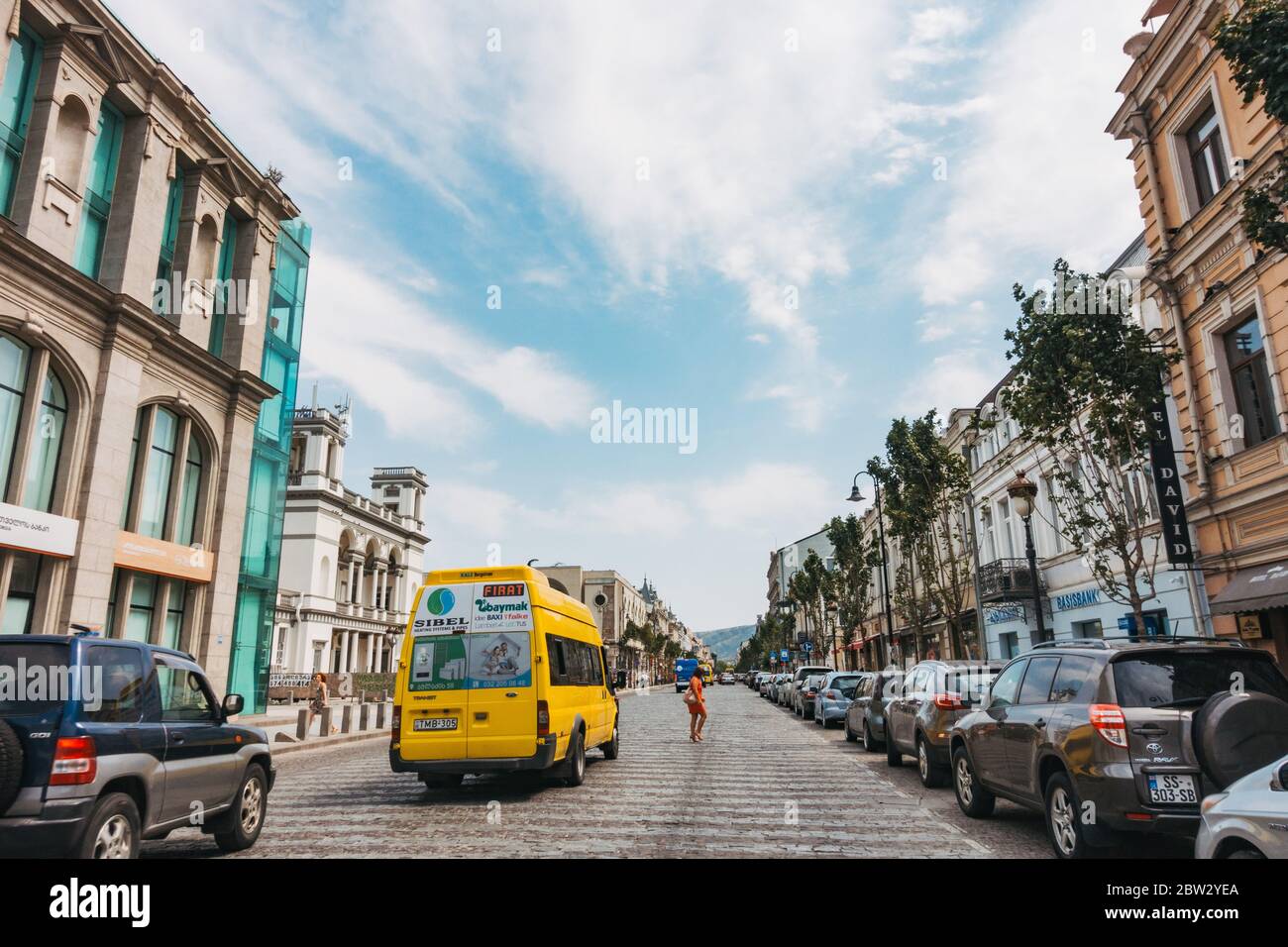 Ein gelber Marshrutka (öffentlicher Kleinbus) führt über die historische Davit Aghmashenebeli Ave, Tiflis, Georgien Stockfoto