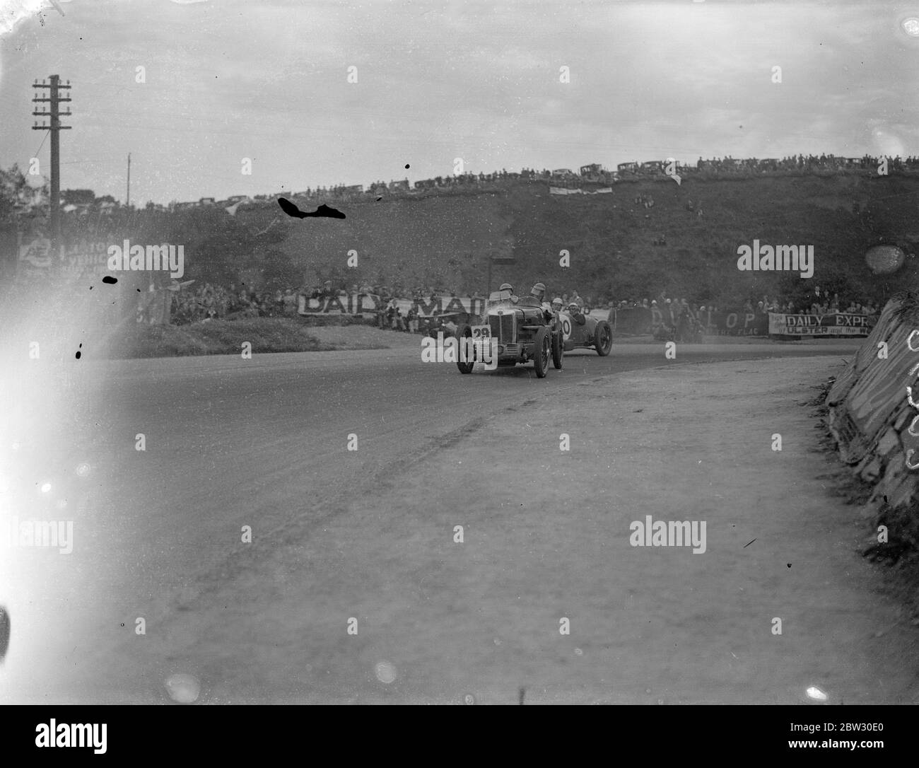 C R Whitcroft gewinnt ulster Tourist Car Rennen nach dem Rennen Nervenkitzel. C R Whitcroft in einem Riley Auto war der Sieger und G E T Eyston, ebenfalls in einem Riley, wurde Zweiter in der Ulster Tourist Trophy Car Race in Belfast, Irland, nach einem der spannendsten Rennen je auf der berühmten Ards Circuit gesehen. Ein allgemeiner Blick wie Autos abgerundeten Quarry Corner während des Rennens. Bis 21. August 1932 Stockfoto