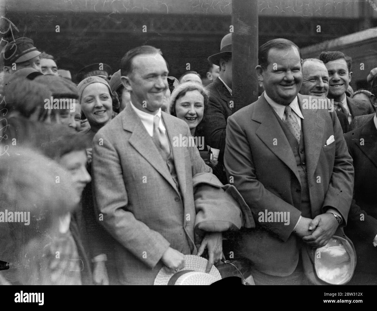 Laurel und Hardy in London. Stan Laurel, dessen richtiger Name Jefferson und sein amerikanischer Partner Oliver Hardy, der Filmkomödianten, sind in London am Waterloo Station, London, auf dem Aquitania-Bootszug angekommen. Stan Laurel und Oliver Hardy bei der Ankunft am Waterloo Station, London. 23 Juli 1932 Stockfoto