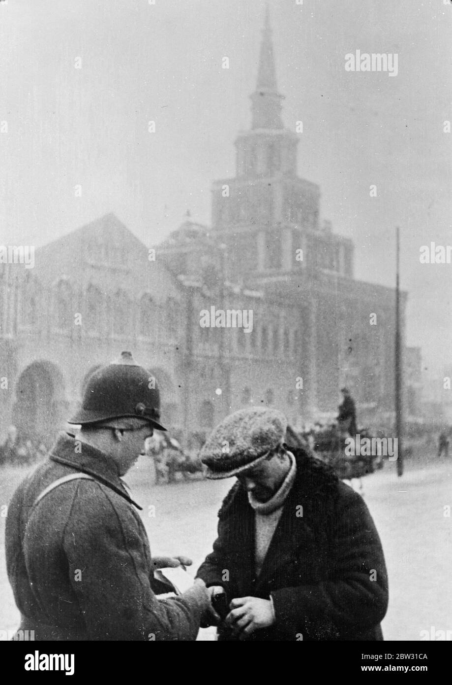 Jay Walkers Geldstrafe auf der Stelle in Moskau . Um die Straßen sowohl für Fußgänger als auch für Autos sicher zu machen, werden jay Walker und Autofahrer jetzt vor Ort in Moskau bestraft, wenn die Einwohner das Gesetz brechen. Ein sowjetischer Arbeiter zahlt seine Geldstrafe an einen Polizisten in einer Moskauer Straße für Jay Walking. Februar 1932 Stockfoto