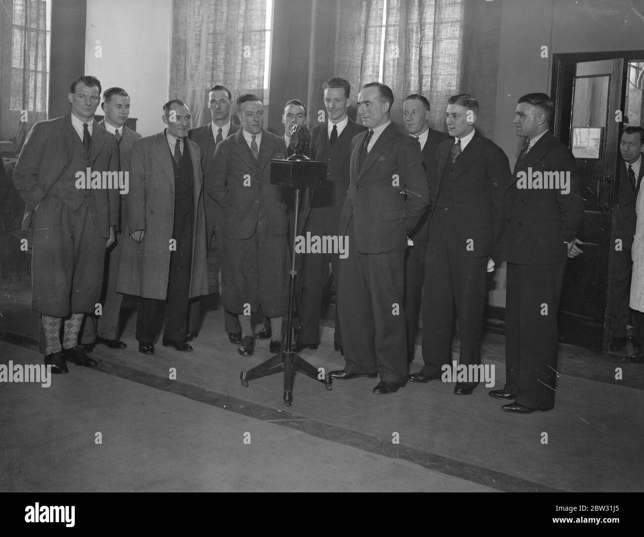 Arsenal Team machen einen Rekord . Das Arsenal-Fußballteam, das Newcastle United im Cup-Finale in Wembley für den F A Cup am 23. April trifft, besuchte die Columbia Studios in London und machte einen Rrecord für das Grammophon. Tom Parker, der Arsenal Captian, spricht für den Rekord, während der Rest des Cup-Teams herumstehen, während ihres Besuchs in den Columbia Studios in London. 30 März 1932 Stockfoto
