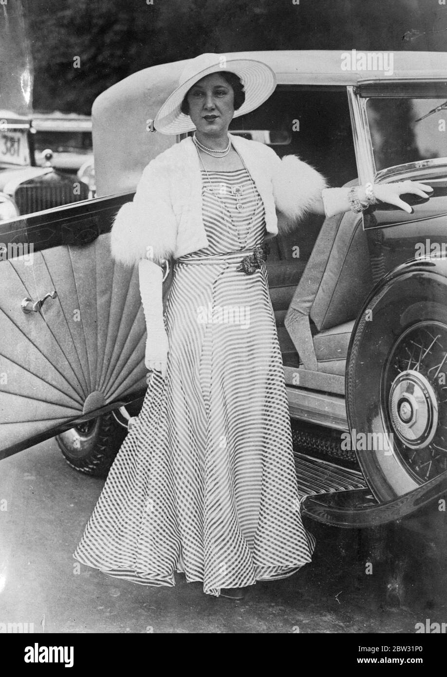 Gestreifter Organist im Paris Concours D'Elegance . Die jährliche Ausstellung von Luxusautos und die begleitende Fashion Parade zogen einen Rekordeintritt und interessierte Menge in den Bois de Boulogne in Paris , wo modische Frauen und gefeierte Schauspielerinnen in den neuesten Modellen erschienen , In vielen Fällen mit ihrer Kleidung, die zum Polster ihrer Autos passt. Florence Walton, die amerikanische Schauspielerin, in einem blau-weiß gestreiften Organdie-Modell, mit drei dunkelroten Samtblumen an der Taille. Der Hut ist aus feinem weißen Strohgeflecht mit einem schwarzen Seidengeflecht Besatz. 25 Juni 1932 Stockfoto