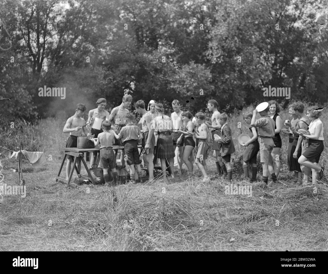 Wildjäger und Entdecker im Camp an der Themse. Kapitän Sarll, der große Wildjäger und Entdecker zeigt eine Partei von Urlaub Camper in Shepperton, eine Auswahl an Lebensmitteln. August 1932 Stockfoto