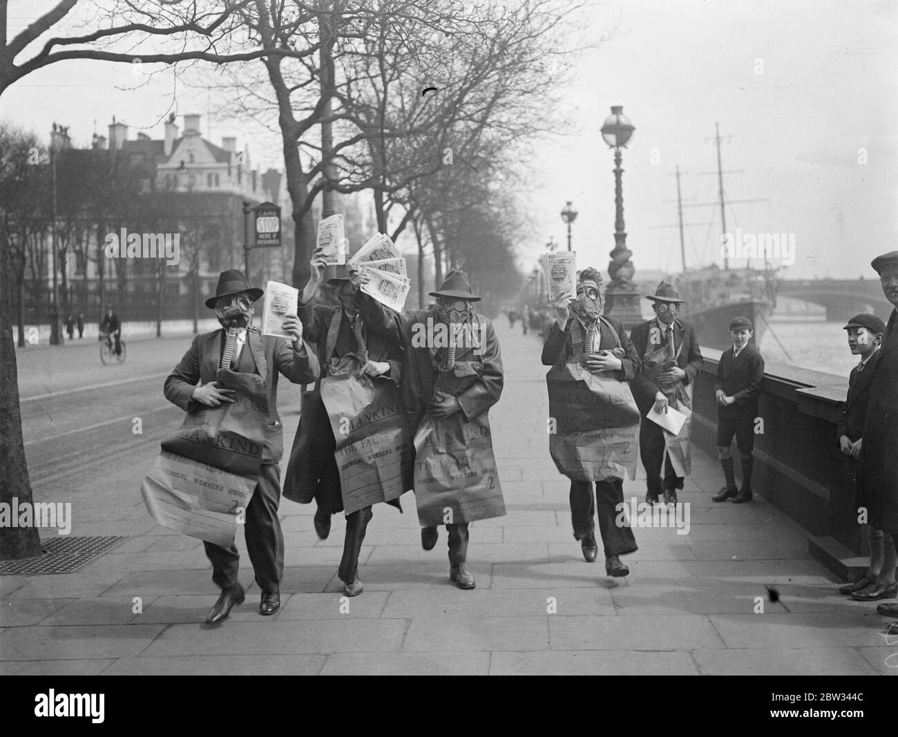 Gasmaskierte Demonstranten veranstalten die Maiparade in London. Demonstranten tragen Gasmasken und tragen Plakate drängen auf die Abschaffung der Gas-und chemischen Krieg, leitete die Maifest Parade durch London, die von der Uferstraße begann. Demonstranten weraing Gasmasken marschieren entlang der Embankment, London bei der Demonstration am 1. Mai. 29. April 1932 Stockfoto