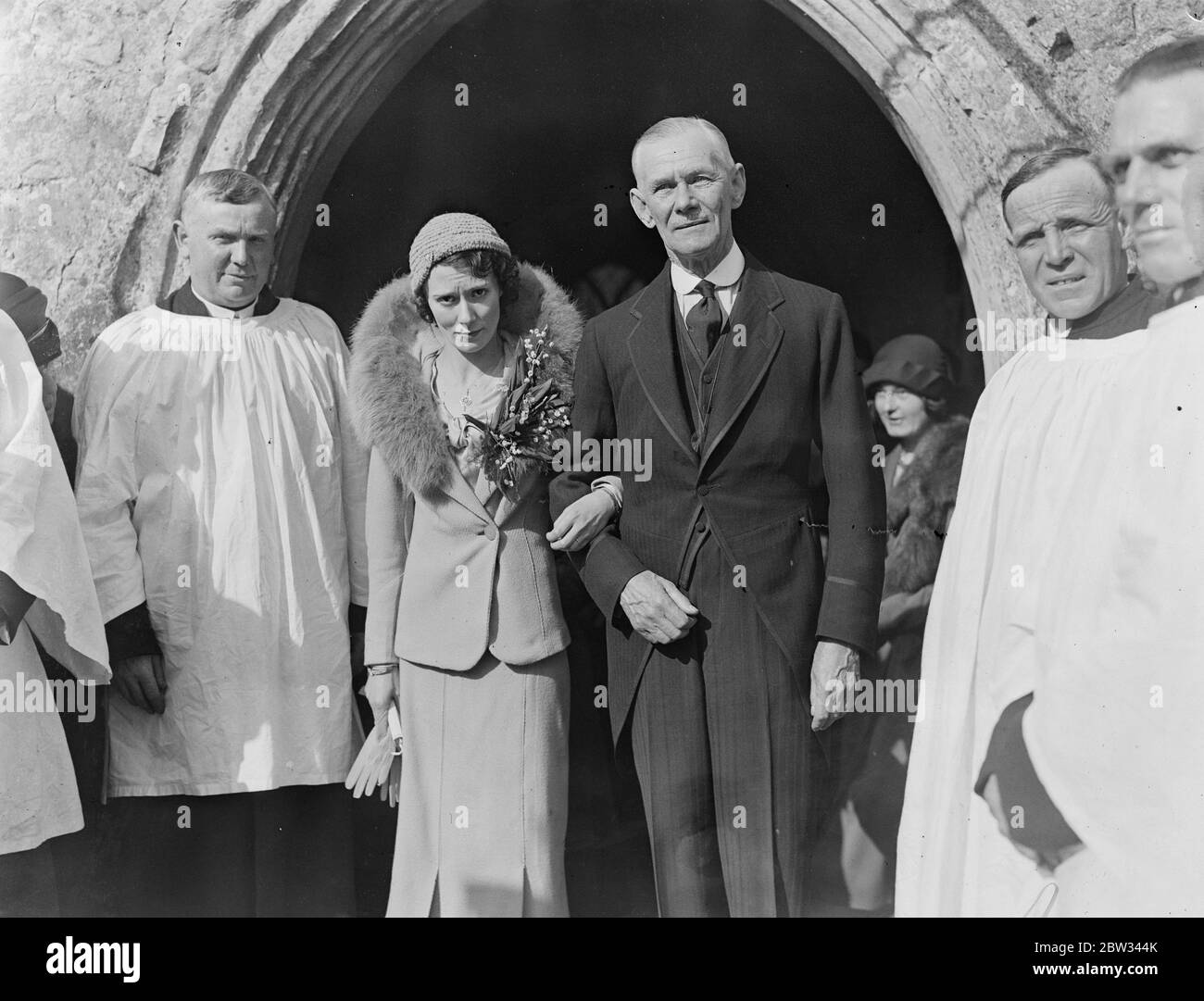 Siebzig sieben Jahre alt Essex Dorf Vikar vermählt zweiunddreißig Jahre alte Krankenschwester. Die Rev RRVC Graves OBE, Vikar von Tolleshunt D'Arcy, war mit Miss Mildred Nicolas verheiratet, eine zweiunddreißig Jahre alte Krankenschwester, in seiner Pfarrkirche in Tolleshunt, Essex. Der 77 Jahre alte Pfarrer. Die Braut und der Bräutigam verlassen die Kirche nach der Zeremonie. April 1932 Stockfoto