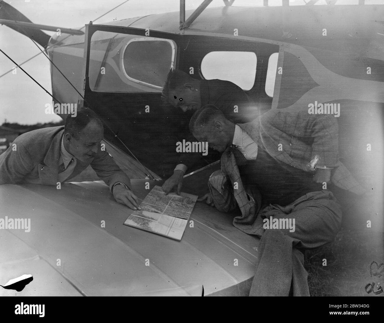 Vorbereitung der Prince of Wales Flugzeug für den König ' s Cup Air Race. Captain W L Hope (rechts) mit seinen beiden Passagieren in Brooklands, wo viele Piloten bereiten ihre Maschinen für die Kings Cup Air Race. Juli 1932 Stockfoto