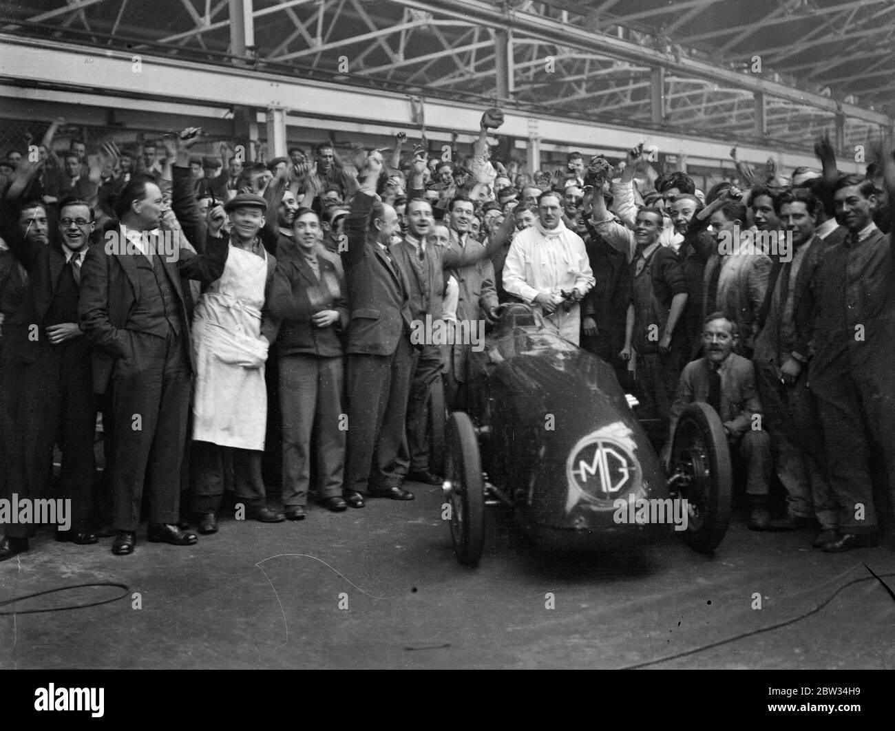 G E T Eyston bereitet sich auf Angriff auf Weltrekord für Baby-Autos in Pendine Sands . Herr G E T Eyston, der Rennfahrer, macht die letzten Vorbereitungen für seinen Versuch, einen neuen Weltrekord für Baby-Autos mit seinem MG The Magic Midget, die auf Pendine Sands, Carmarthenshire, Wales stattfinden wird. Er wird einen speziell angefertigten Asbestanzug tragen. Das Auto wird angefeuert, als es die Abingdon-Garage verließ, wo es gebaut wurde, für Pendine, Wales. Februar 1932 Stockfoto