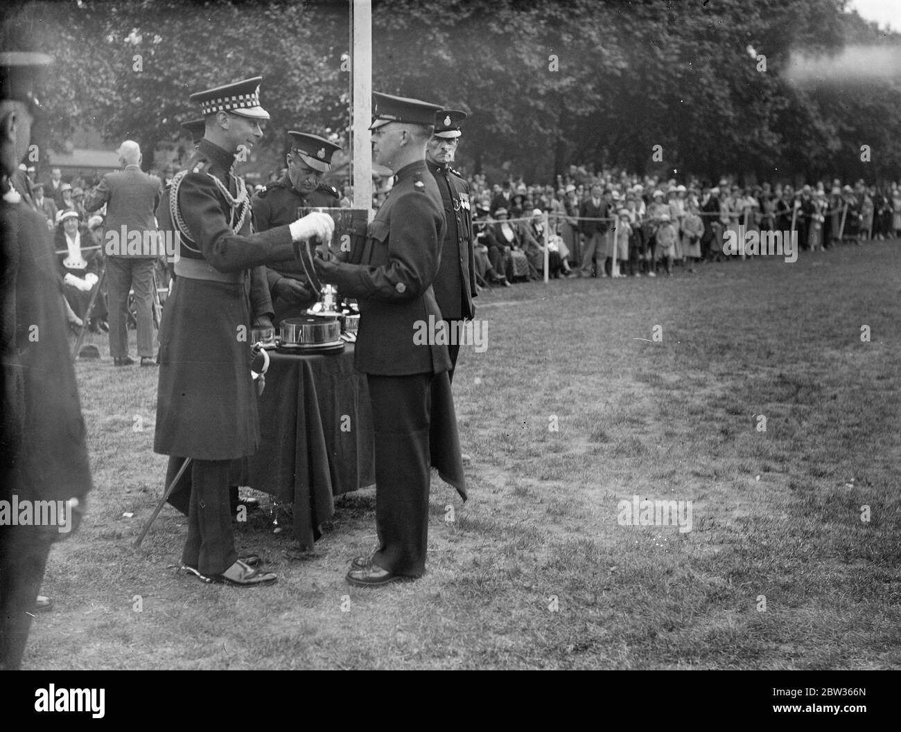 Duke of York präsentiert Tasse bei der Inspektion des Metropolitan Special Constabulary Reserve im Hyde Park . Der Herzog von York inspizierte das Metropolitan Special Constabulary Reserve im Hyde Park, London und überreichte Pokal und Medaillen an verschiedene Teams. Der Herzog von York präsentiert die Barclay Walker Challenge Drill Cup , gewann von der 7. Division ( Croydon ) und erhielt von Inspector D EIN Dennis . 11 Juni 1933 Stockfoto