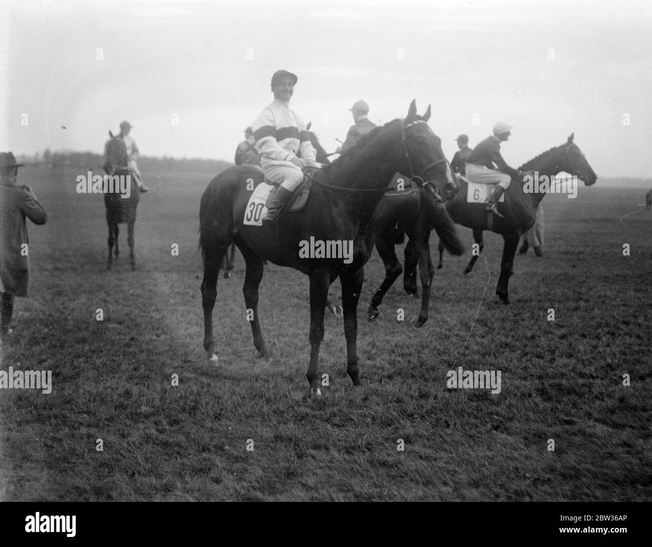 Rennpferd Manitioba mit G Richards Reiten , andere Pferde und Reiter im Hintergrund . Juni 1933 Stockfoto