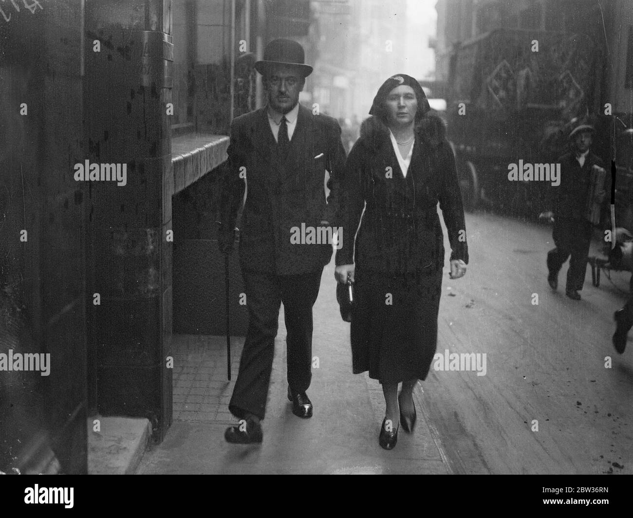 London Bergungschef geht an Bow Street Polizeigericht. Kapitän Brynmor Eric Miles, Leiter des London Salvage Corps, der der Verschwörung mit Leopold Harris, dem Leiter der Feueraufhebung Gang beschuldigt wird, gab sich auf seine Kaution am Bow Street Police Court. Foto zeigt ; Kapitän Meilen auf dem Weg zur Bow Street für die Anhörung der Anklagen gegen ihn begleitet von seiner Frau . 25. November 1933 Stockfoto