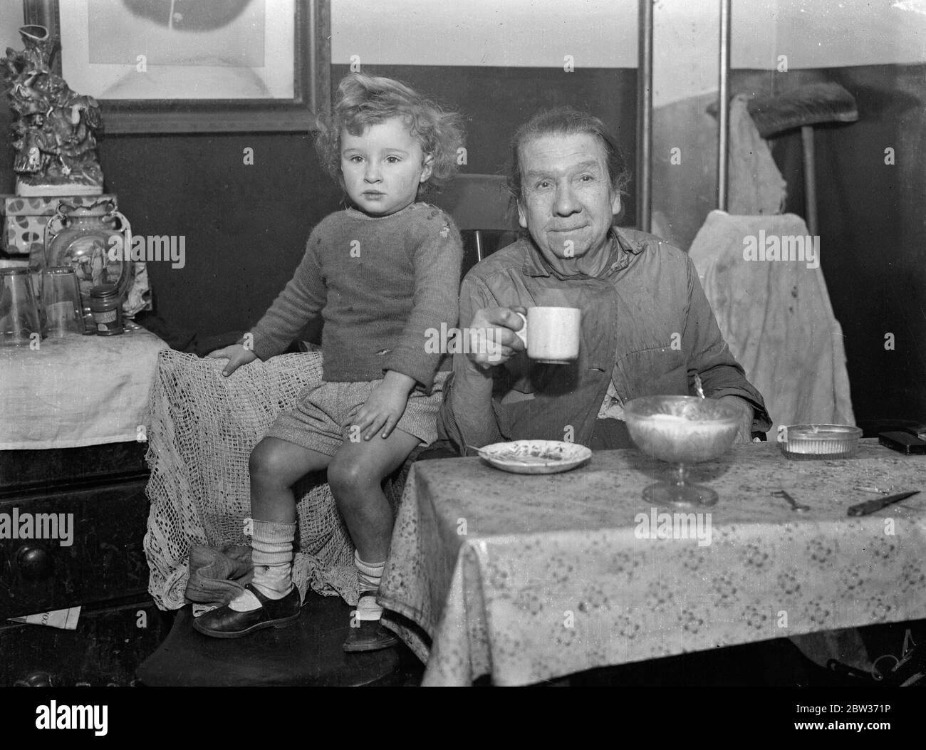 Frauen, die einen Prinzen einen Liebling genannt. Als der Prinz von Wales besuchte die St Marylebone Wohnsiedlung in der Church Street, Edgware Road, Frau Miles, eine ältere Frau Resident eingeladen hm, ihr Zimmer zu sehen. "Komm mit Liebling" sagte sie. Der Prinz lachte über die Verlieblichkeit und erklärte sie zu einem "großen Kompliment". Foto zeigt ; Frau ( Oma ) Meilen . Dezember 1933 Stockfoto