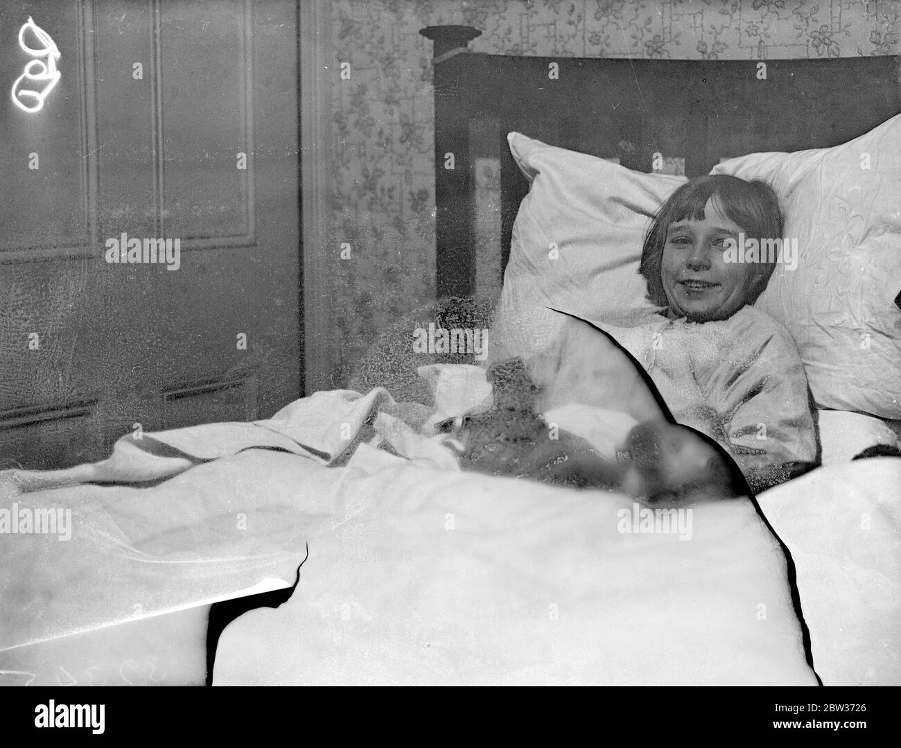 London Mädchen im Bett von Einbrechern gesperrt. Doreen Collier, die zehnjährige Tochter von Frau Collier von Palmers Green, London, wurde im Schlafzimmer ihres Hauses eingesperrt, als Einbrecher das Haus betraten und durchwühlten, indem sie eine große Menge an Schmuck nahmen. Foto zeigt; kleine Doreen Collier im Schlafzimmer, in dem sie von Einbrechern in Belmont Avenue gefangen genommen wurde, Palmers Green. Dezember 1933 Stockfoto