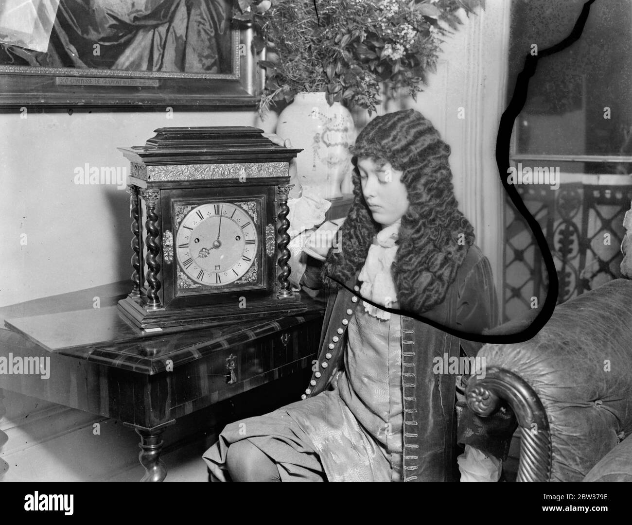 König Charles II Ausstellung von Reliquien eröffnet in London. Eine Ausstellung der Reliquien der Zeit König Charles II, wurde in London in Hilfe der jungen Frauen "Christian Association in Grosvenor Place London eröffnet. Illustrieren König Charles Leidenschaft für Uhren ein Zimmer wurde mit mehr als fünfzig Uhren seiner Zeit. Foto zeigt Lauretta Hope Nicolson , neben einer Uhr aus der Zeit von König Karl II , und in das Kostüm der Zeit gekleidet . 28. Januar 1932 Stockfoto König Charles II Ausstellung von Reliquien eröffnet in London. Eine Ausstellung der Reliquien der Zeit König Charles II, wurde in London in Hilfe der jungen Frauen "Christian Association in Grosvenor Place London eröffnet. Illustrieren König Charles Leidenschaft für Uhren ein Zimmer wurde mit mehr als fünfzig Uhren seiner Zeit. Foto zeigt Lauretta Hope Nicolson , neben einer Uhr aus der Zeit von König Karl II , und in das Kostüm der Zeit gekleidet . 28. Januar 1932 Stockfoto