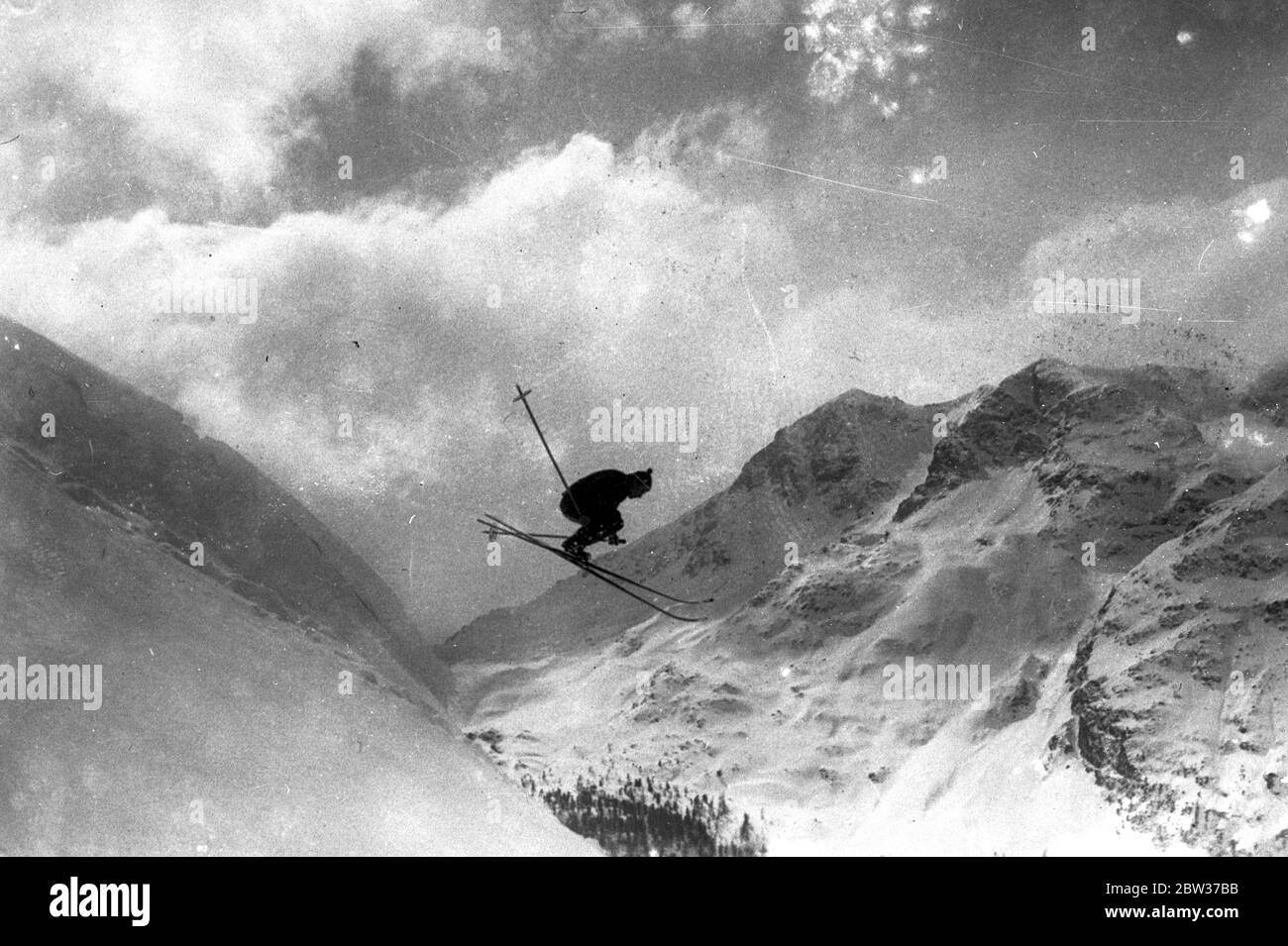 Ein wagemutiger Sprung im Schweizer Wintersport. Ein Konkurrent im Schweizer Wintersport, der jetzt in St. Moritz stattfindet, macht einen wagemutigen Sprung in den Alpen. 30 Dezember 1933 Stockfoto