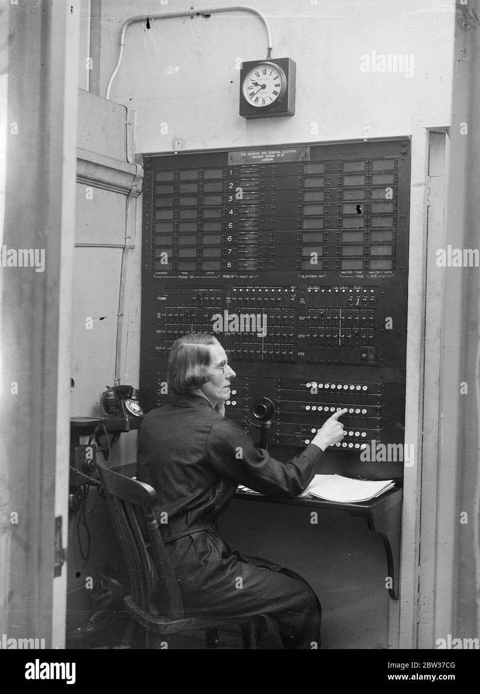 Miss M F Miller wurde mit der Aufgabe betraut, sicherzustellen, dass die Tausenden von Menschen, die Paddington Station , London , über die Bewegungen der Züge informiert werden und dass sie die richtigen finden können. Sie sitzt in einem kleinen Raum über dem Bahnhof und blickt auf eine mit Blinkern beborstende Schalttafel und steuert eine aufwändige elektrische Anzeige im Hauptbereich des Bahnhofs, die alle Informationen gibt, die Passagiere über die Züge benötigen. Der Indikator ist der erste seiner Art in der Welt. Foto zeigt, Miss M F Miller bei der Arbeit in ihrem Kontrollraum in Paddington. 28 MIO. Stockfoto