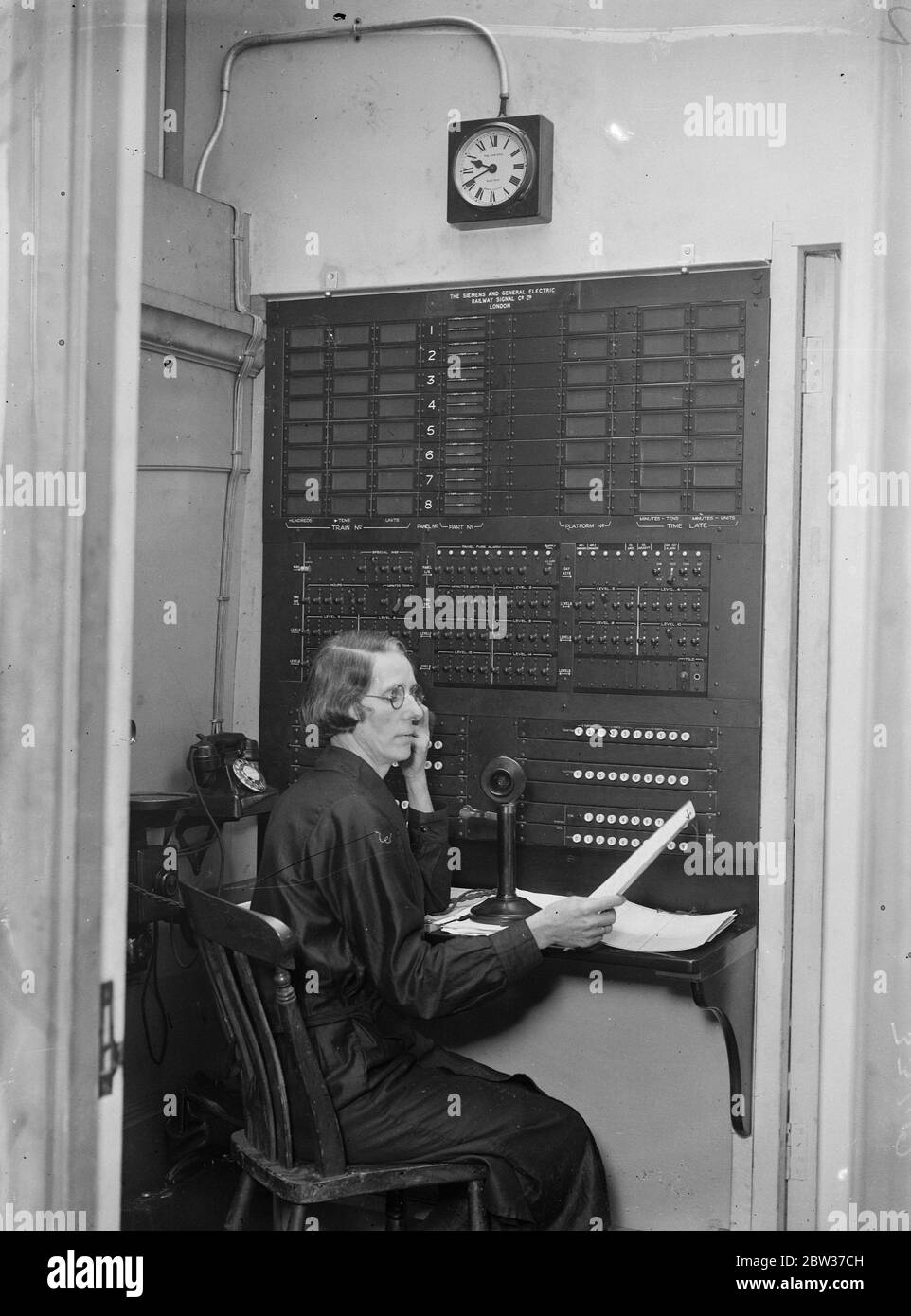 Miss M F Miller wurde mit der Aufgabe betraut, sicherzustellen, dass die Tausenden von Menschen, die Paddington Station , London , über die Bewegungen der Züge informiert werden und dass sie die richtigen finden können. Sie sitzt in einem kleinen Raum über dem Bahnhof und blickt auf eine mit Blinkern beborstende Schalttafel und steuert eine aufwändige elektrische Anzeige im Hauptbereich des Bahnhofs, die alle Informationen gibt, die Passagiere über die Züge benötigen. Der Indikator ist der erste seiner Art in der Welt. Foto zeigt, Miss M F Miller bei der Arbeit in ihrem Kontrollraum in Paddington. 28 MIO. Stockfoto