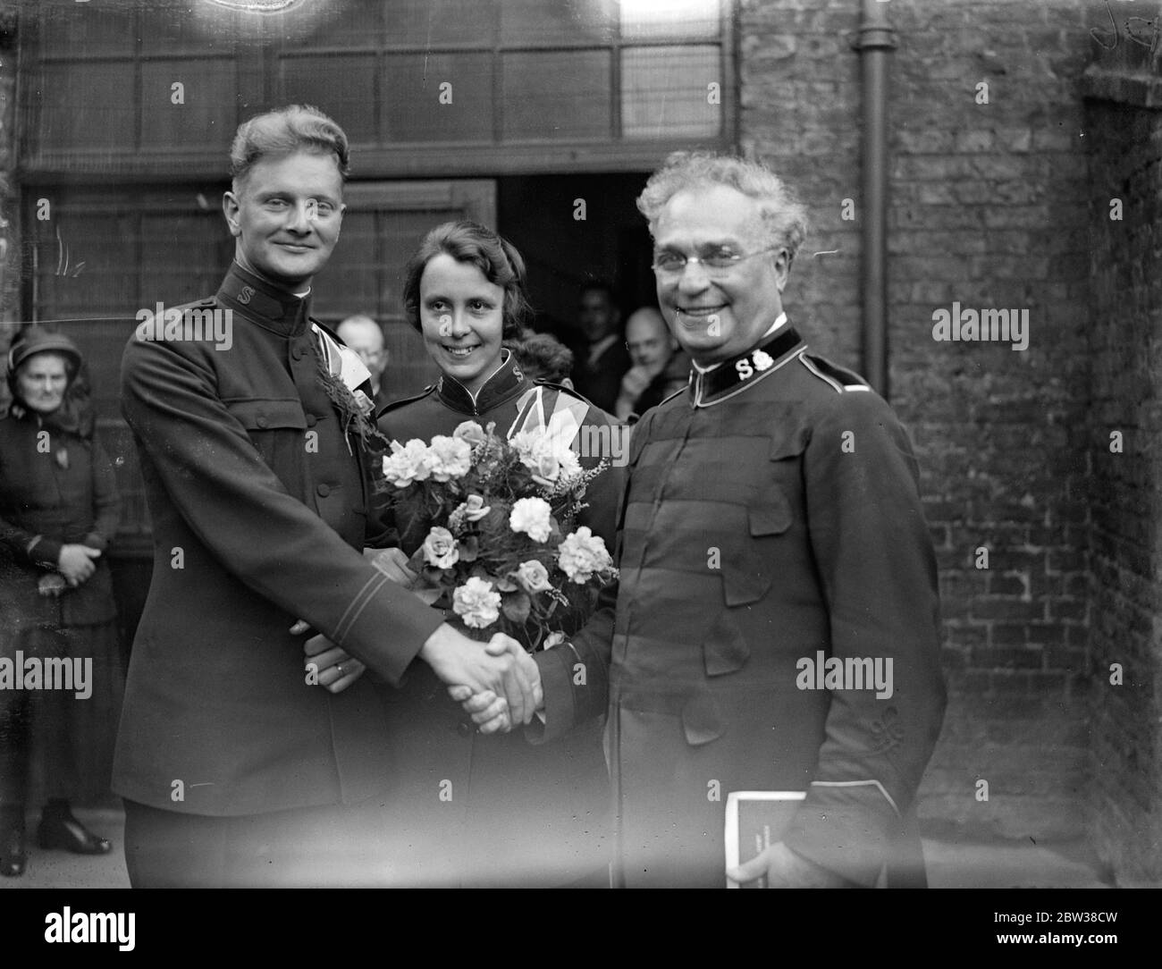 Kapitän Sture Larsson, Kommandant Offizier des Streatham Vale Corps der Heilsarmee, war in der Penge Zitadelle zu Captian Flora Benwell von International Headquarters verheiratet. Foto zeigt die Braut und Bräutigam wird von Kommissar Napp gratuliert , der die Zeremonie durchgeführt , nach der Hochzeit . 11. September 1934 Stockfoto