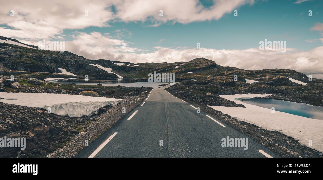 Panoramafoto der Scenic Scandinavian Alpine Route. Fahrt durch die norwegische Amazing Raw Nature. Felsen, Schnee, See und der Horizont. Stockfoto