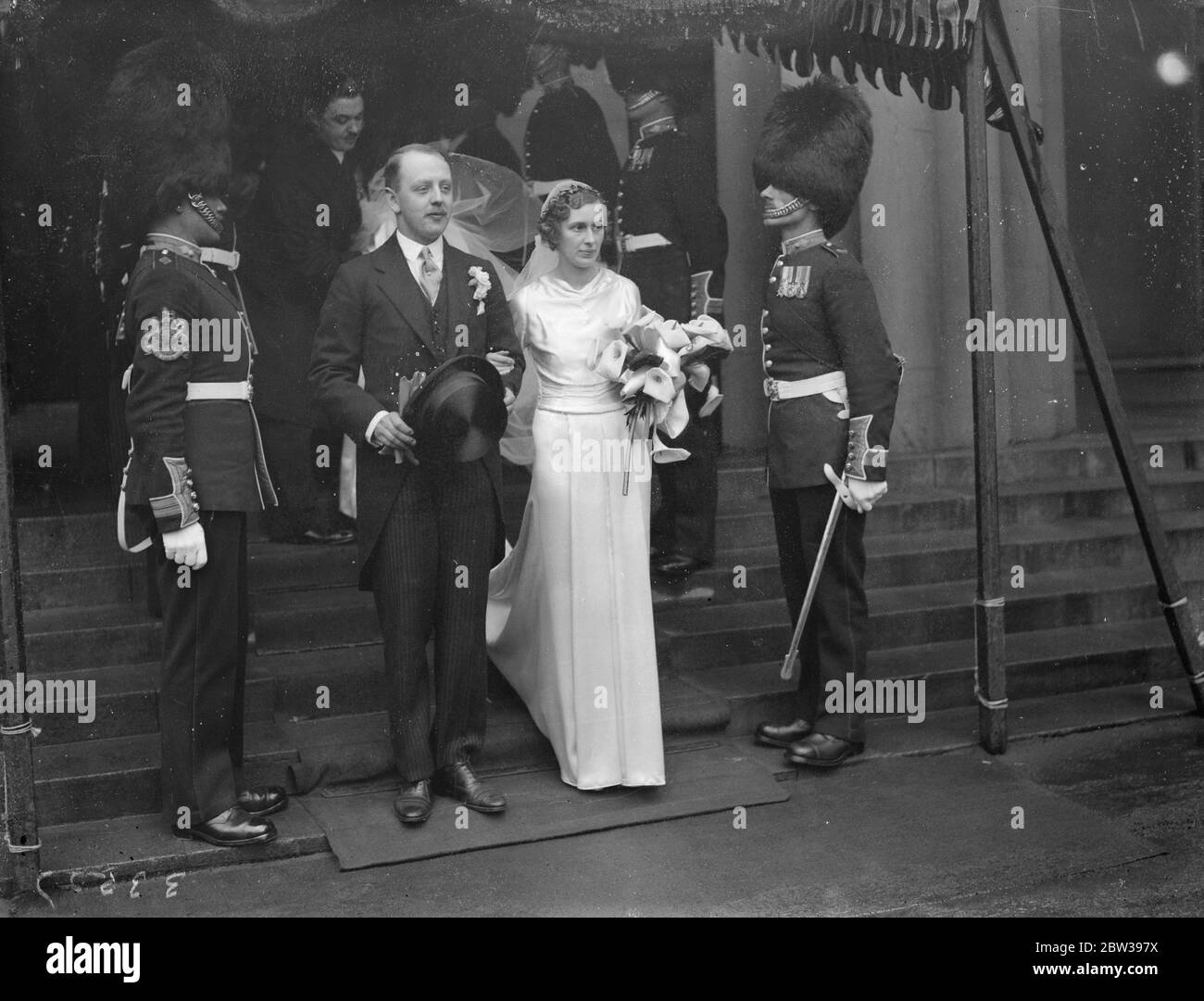 Cousin von Lord Desborough heiratete in der Royal Military Chapel. Herr Pascoe Glyn von den Grenadier-Garden war in der Royal Military Chapel, Wellington Barracks, mit Frau Katherine Grenfell verheiratet, ein Cousin von Lord Desborough und die Tochter von Oberst und Frau Arthur Grenfell. Die Braut trug einen Zug sieben Meter lang. Foto zeigt, die Braut und Bräutigam verlassen durch die Wache der Ehre. 18 April 1934 . 30er, 30er, 30er, 30er, 30er, 30er, 30er, 30er Stockfoto