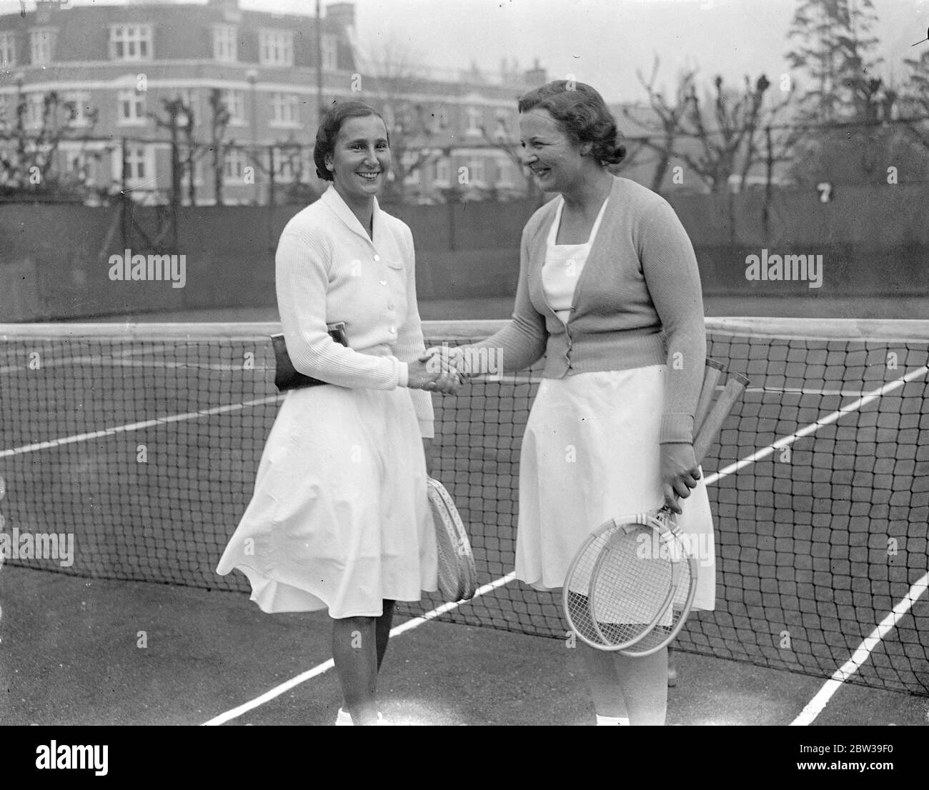 Britische Tennisspielerinnen; Betty Nutall (rechts) und Dorothy Round schütteln Hand auf dem Tennisplatz. 28. April 1934 Stockfoto