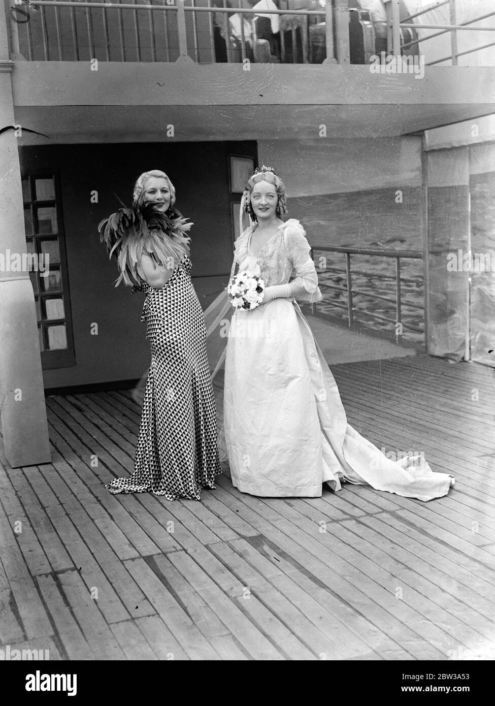 Mädchen mit sechzehn Zoll Taille trägt 1863 Hochzeitskleid bei Whiteley ' s Geburtstagsfeier . All Paddington feiert den 71. Geburtstag von Whiteley ' s, eines der berühmtesten Kaufhäuser Londons. Ein Merkmal der Feierlichkeiten war eine "Cavalcade of Fashion", in dem über fünfzig der Welt "schönsten Mannequins zeigten Veränderungen in der weiblichen Kleidung seit 1863. Unter ihnen waren Miss Diana Vawsher, deren sechzehn Zoll Taille ermöglicht ihr, ein Brautkleid 1863 tragen. Foto zeigt, Miss Diana Vawsher trägt das Brautkleid 1863. Mit ihr ist ein Mädchen, das eine moderne Mode trägt. 30. April 19 Stockfoto
