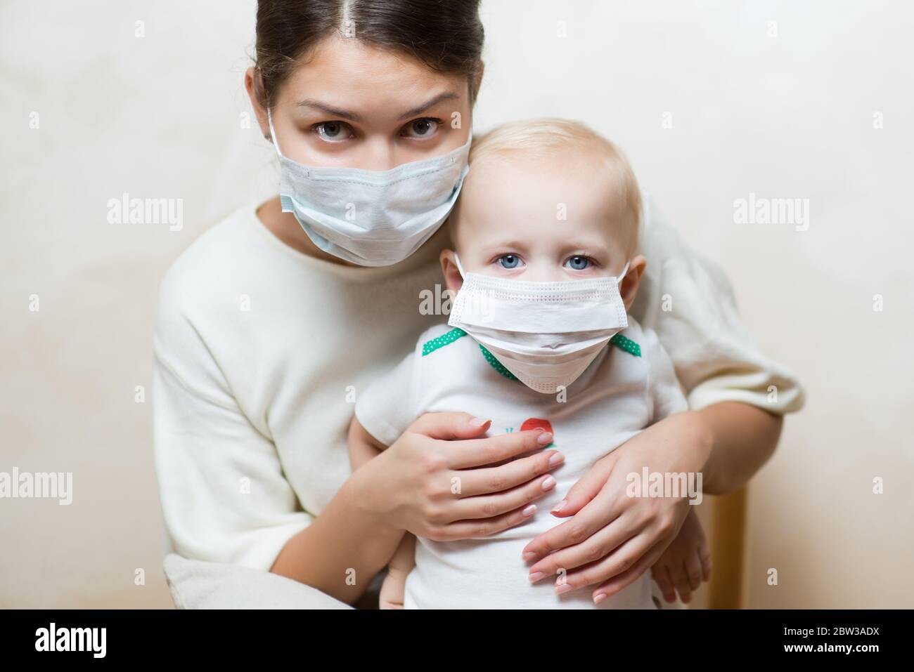 Frau und ein Baby in medizinischen Masken Stockfoto
