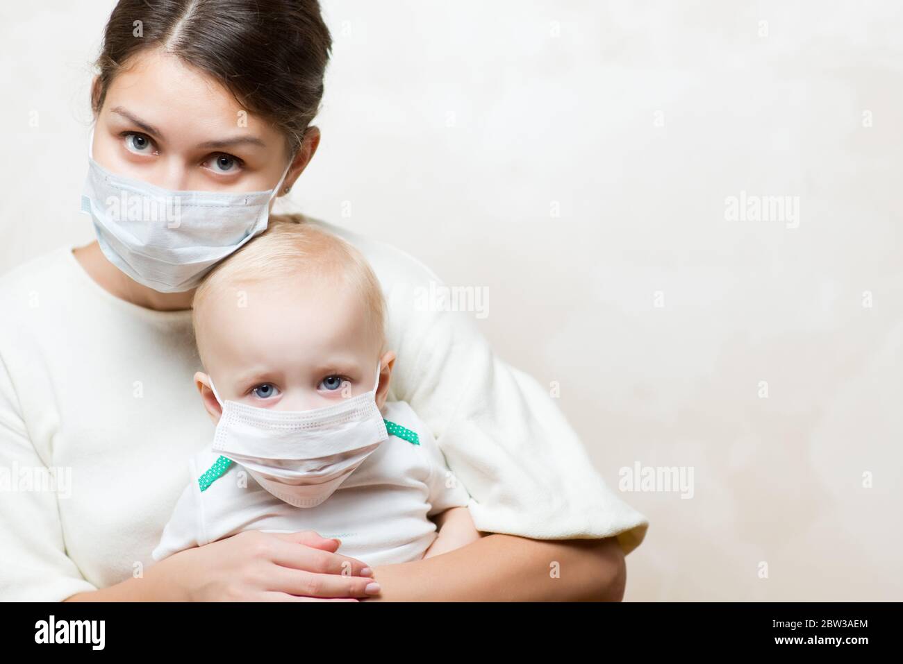 Frau und ein Baby in medizinischen Masken, Kopierraum Stockfoto