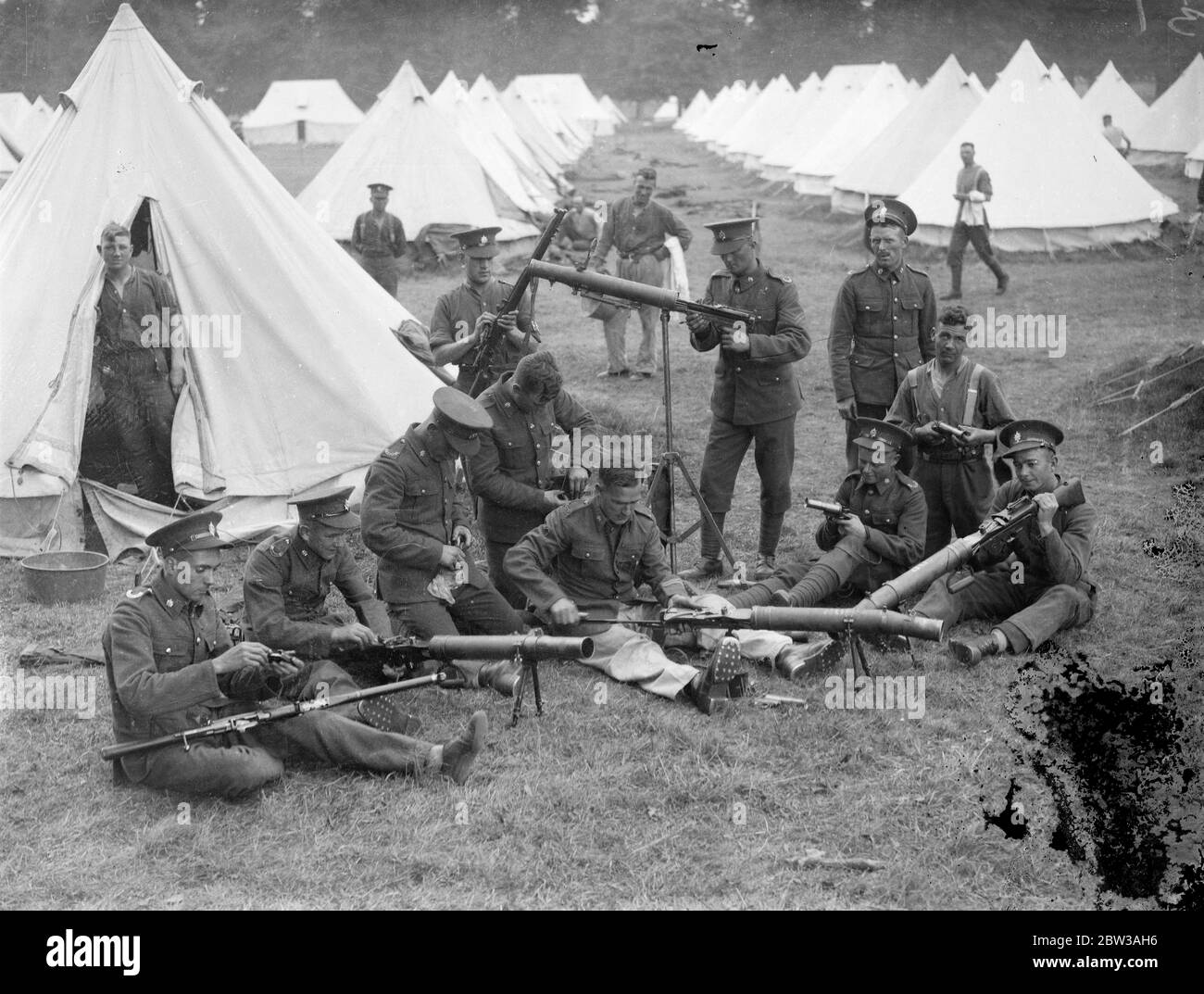 Armee inszeniert große Manöver auf Salisbury Plain . Die 23. Feldbrigade Royal Artillery kehrte nach einem Angriff auf die ' Westland Truppen ' unter dem Kommando von Brigadier W Green ins Lager zurück. Sie stehen unter dem Kommando von Brigadier A F Brooke, der die Eastland-Truppen kontrolliert. Sofort nach ihrer Rückkehr, Soldaten der 23. Feldbrigade gereinigt das Lager und die Waffen. Foto zeigt Soldaten der 28. Feldbrigade Royal Artillery Reinigung ihrer Waffen, mit Reihen von Zelten im Hintergrund. 12. September 1934 Stockfoto