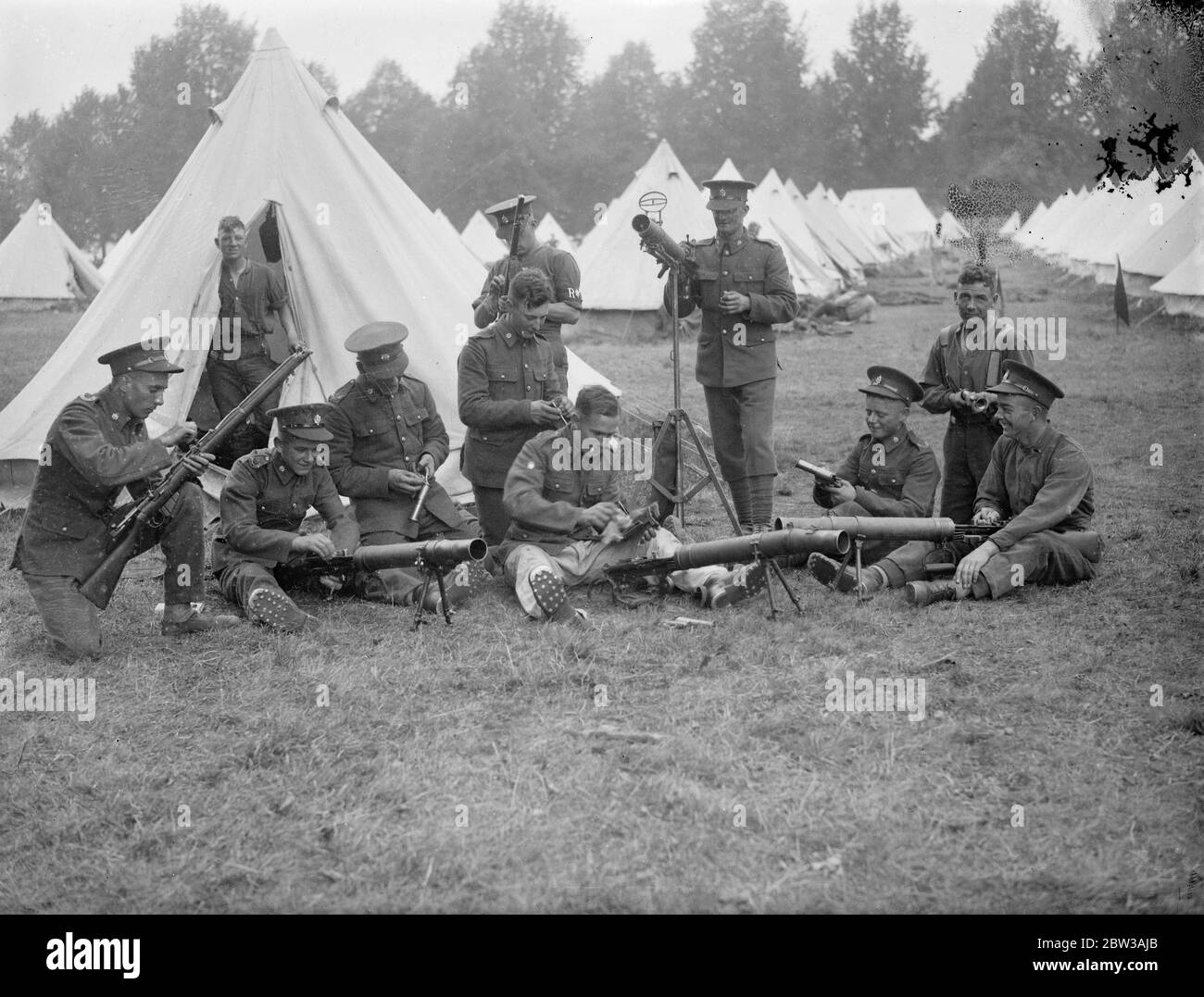 Armee inszeniert große Manöver auf Salisbury Plain . Die 23. Feldbrigade Royal Artillery kehrte nach einem Angriff auf die ' Westland Truppen ' unter dem Kommando von Brigadier W Green ins Lager zurück. Sie stehen unter dem Kommando von Brigadier A F Brooke, der die Eastland-Truppen kontrolliert. Sofort nach ihrer Rückkehr, Soldaten der 23. Feldbrigade gereinigt das Lager und die Waffen. Foto zeigt Soldaten der 28. Feldbrigade Royal Artillery Reinigung ihrer Waffen, mit Reihen von Zelten im Hintergrund. 12. September 1934 Stockfoto