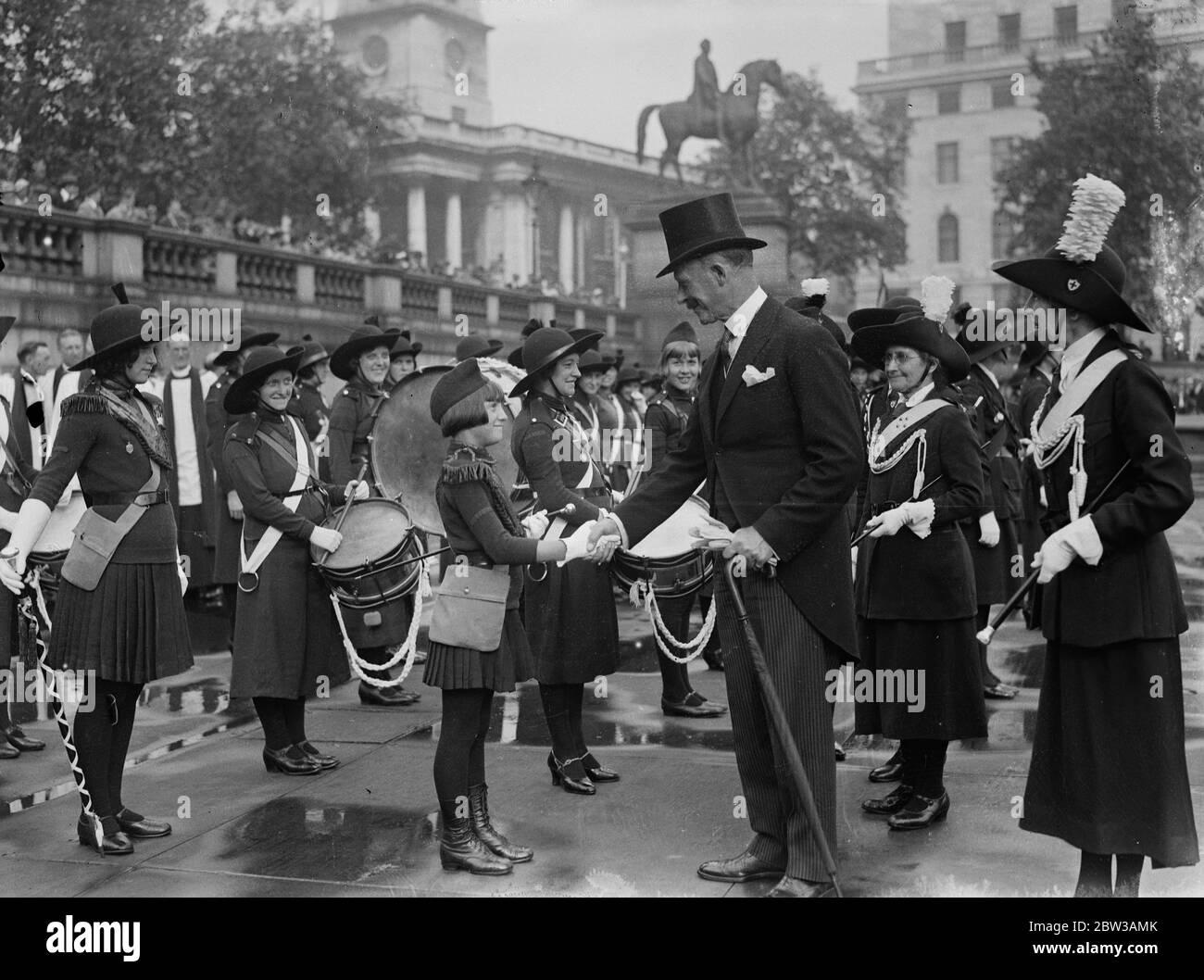 Church Girls' Brigade halten jährliche Parade in Trafalgar Square . Colonel Beyle schüttelt sich bei einer Inspektion der Brigade mit dem kleinen Drum Major die Hände. 15. September 1934 Stockfoto