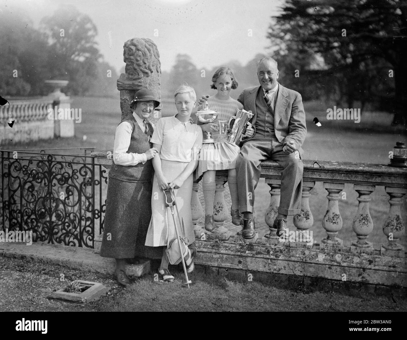 13 Jahre altes Mädchen Golf Champion . Kleine Nancy Jupp 13 Jahre altes Wundermädchen hält die Tasse, posiert mit ihrer Familie. 14. September 1934 Stockfoto