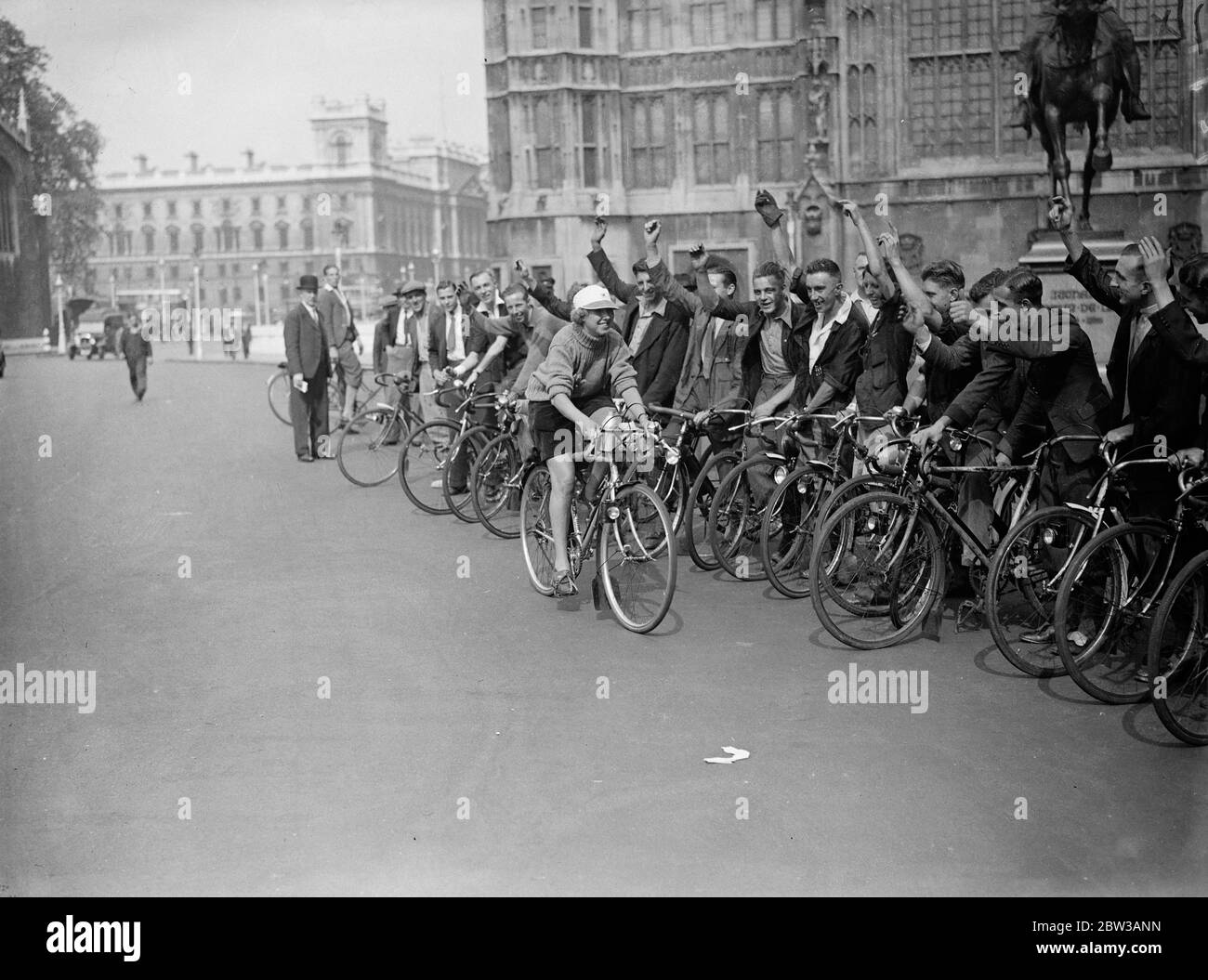 Miss Evelyn Hamilton, die Frauen s Radsportmeisterin, versucht, 1, 000 Meilen in einer Woche zu decken. Foto zeigt Miss Hamilton auf ihrem Fahrrad, das an einer Reihe männlicher Radfahrer vorbeifährt 14. September 1934 Stockfoto