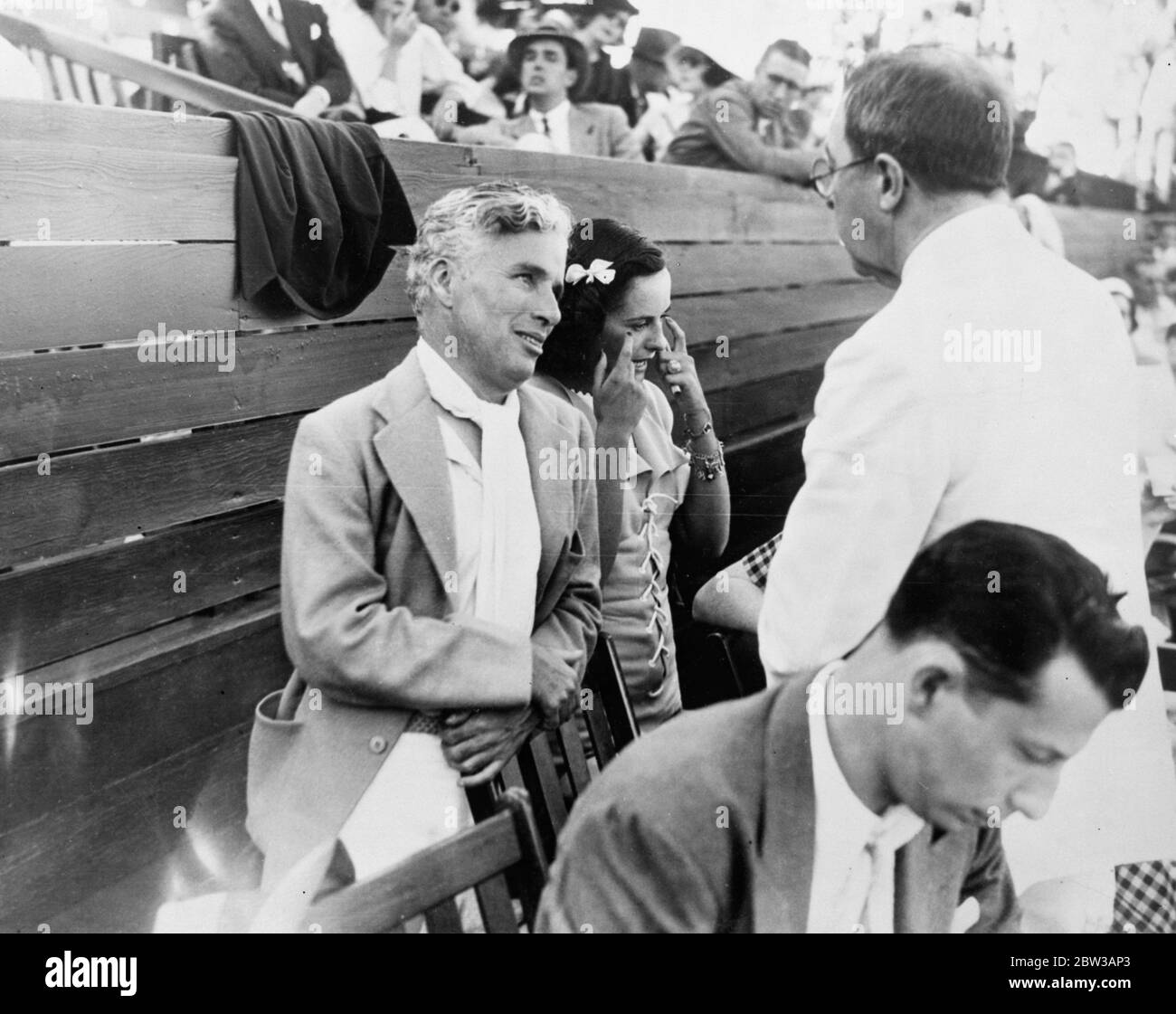 Charles Chaplin und Paulette Goddard zusammen beim Tennisturnier. Foto zeigt, Charles Chaplin und Paulette Goddard im Gespräch mit einem Freund auf dem Turnier in Los Angeles Tennis Club. 27. September 1934 Stockfoto